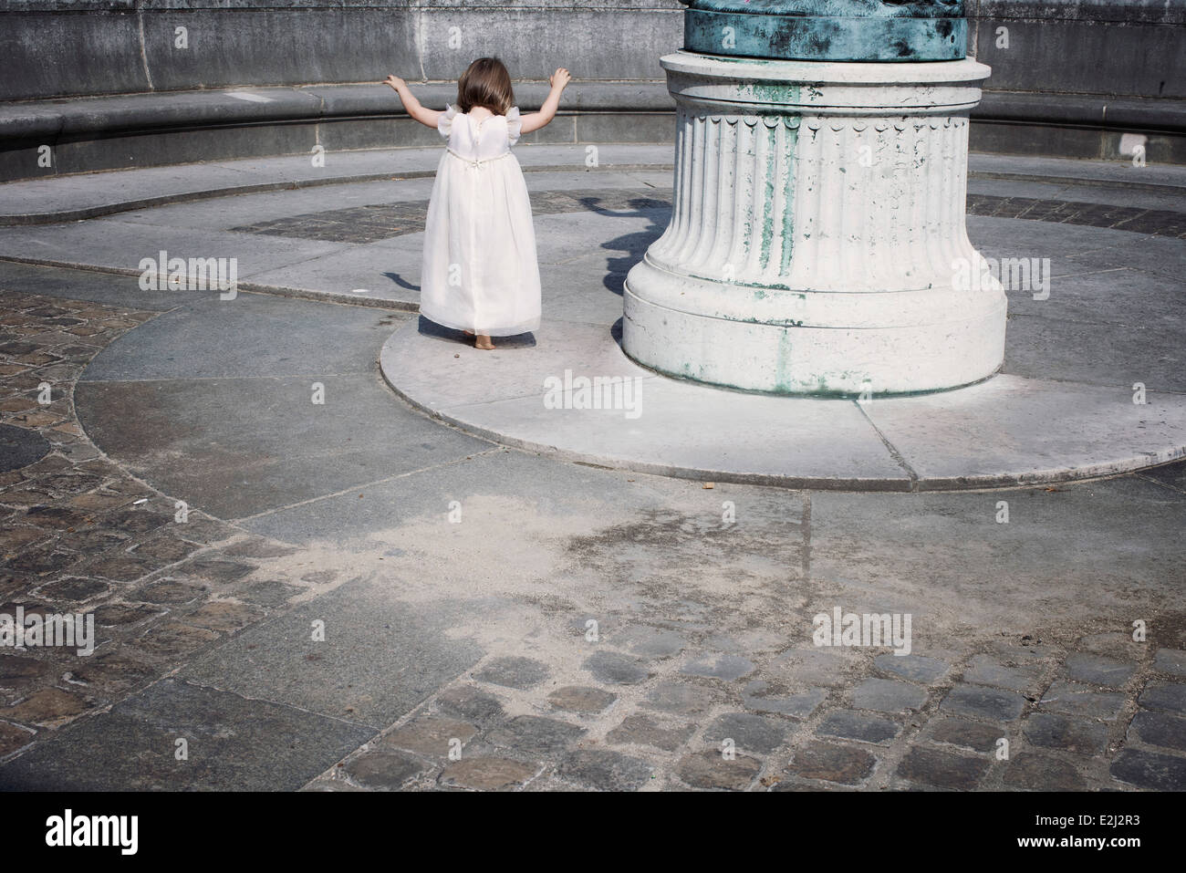 Little girl playing alone outdoors Stock Photo