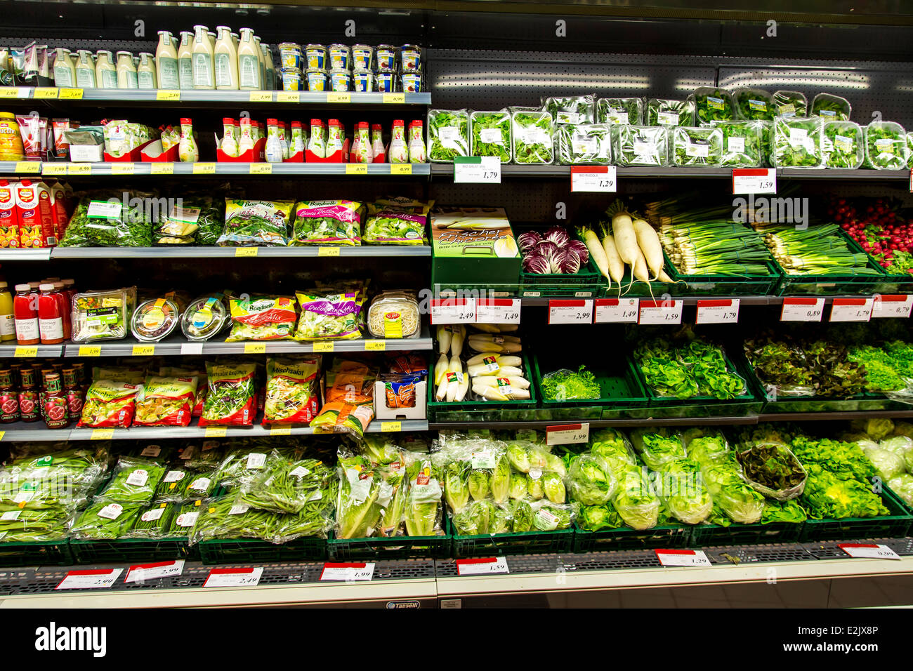 Shelf with food in a supermarket. Refrigerated, fruit juices, salad, vegetables, packed in plastic, Stock Photo