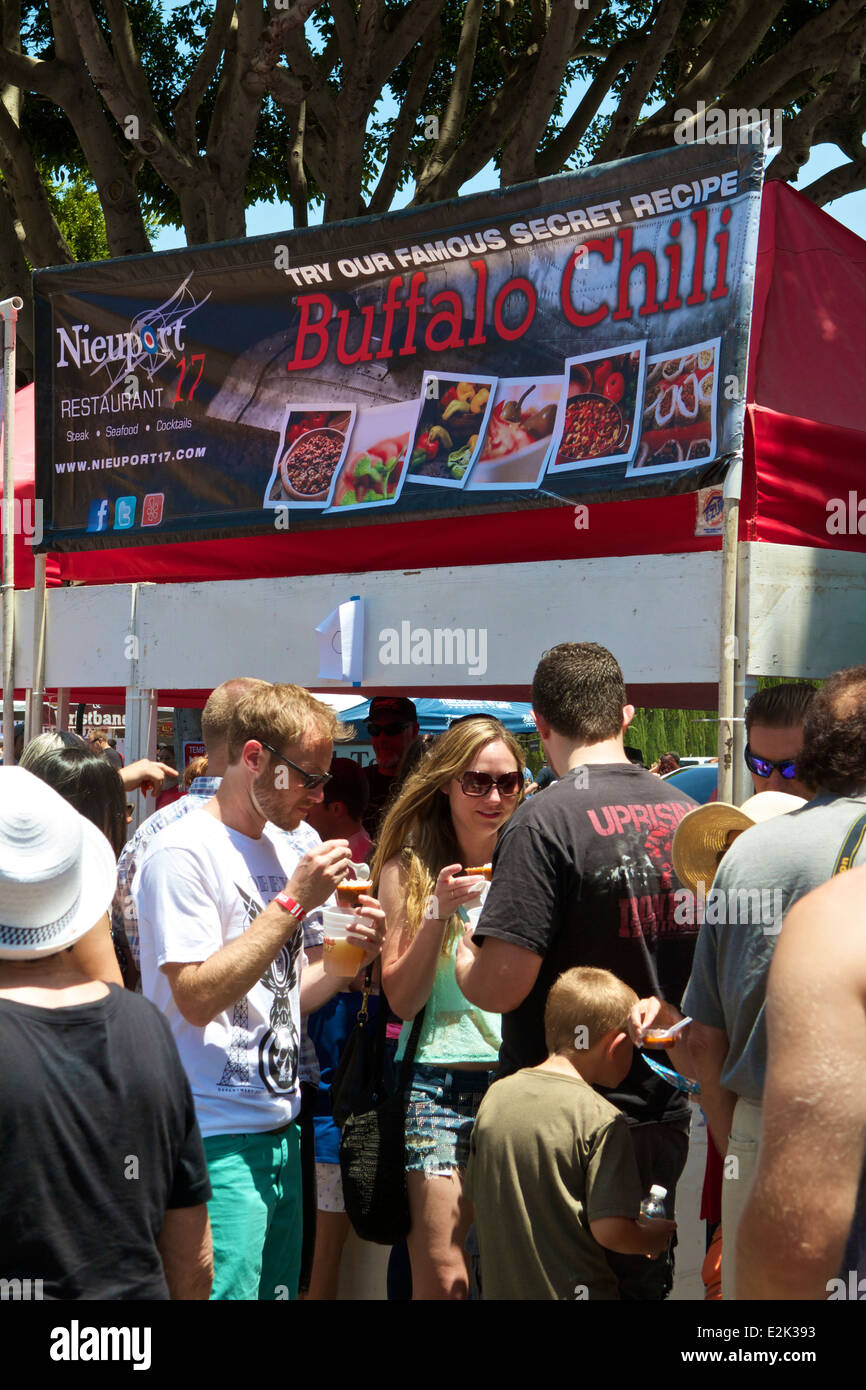 Visitors sample chili at a competitors stall at a chili cook off at the