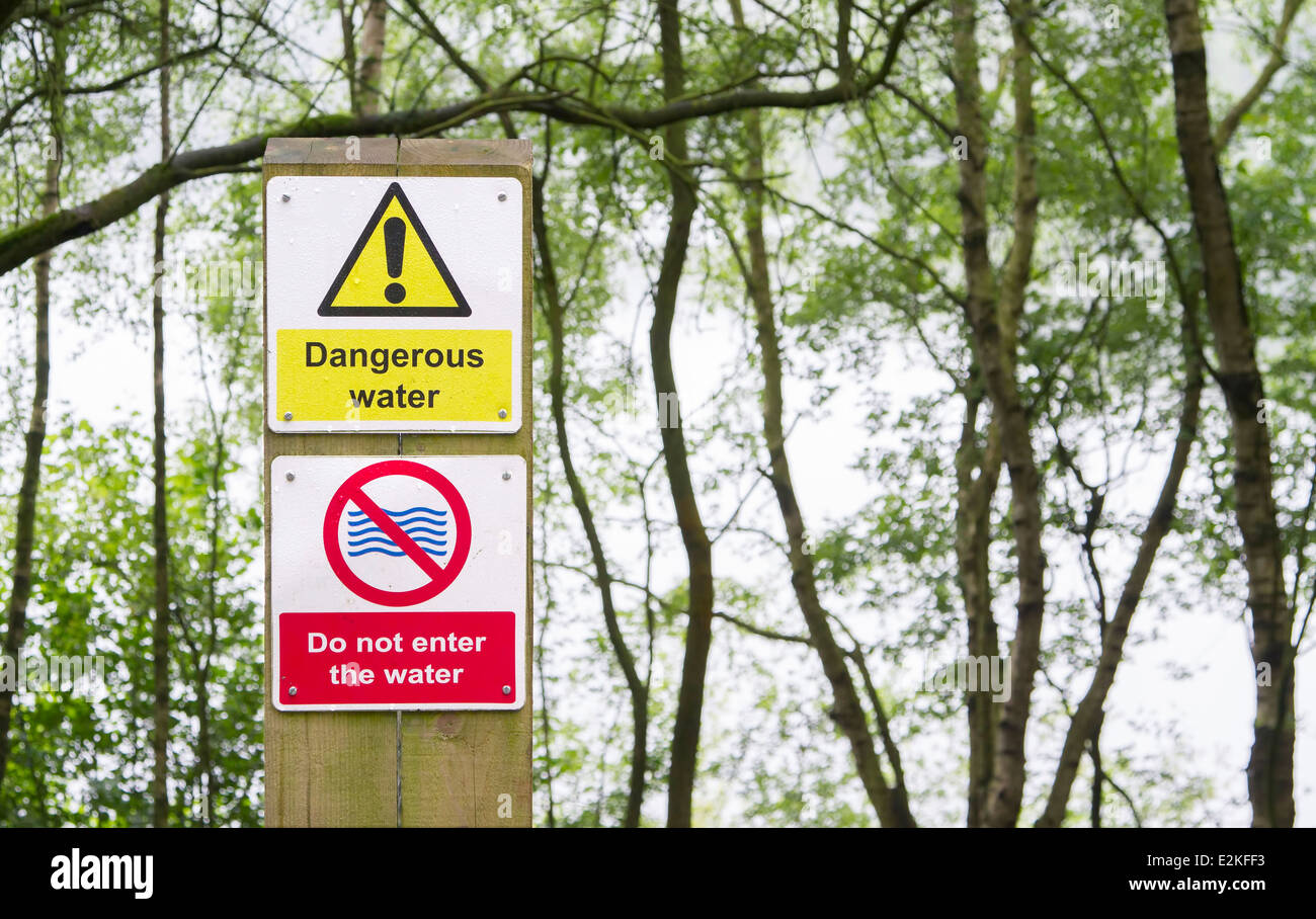 Dangerous water sign at edge of quarry lake Stock Photo Alamy