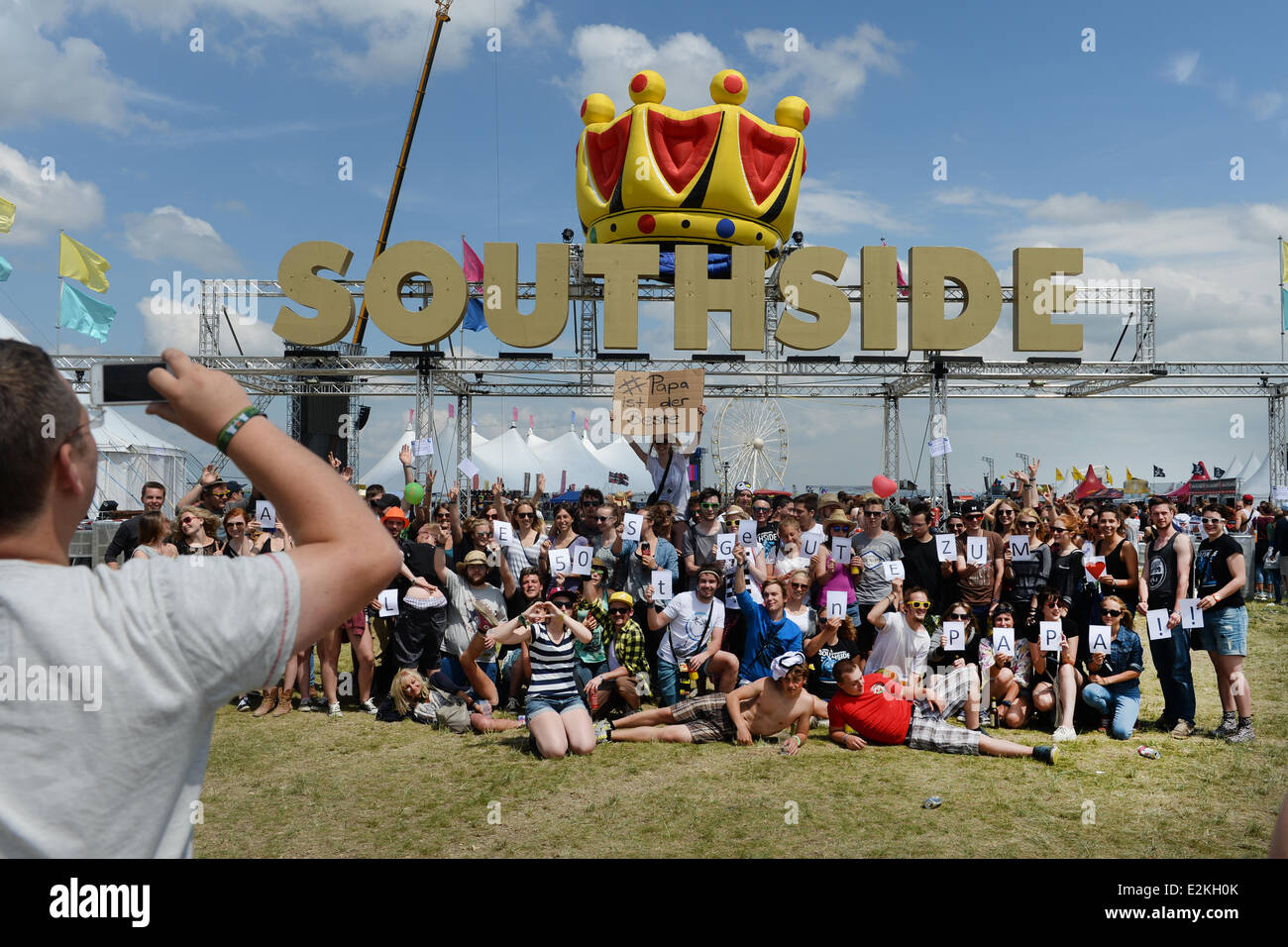Fifty visitors pose for visitor Anja Seehaus from Weinheim whose father celebrates his 50th birthday on Friday at the Southside Festival in Neuhausen ob Eck, Germany, 20 June 2014. Anja Seehaus made a sign with the line 'Dad is the best'. Photo: FELIX KAESTLE/dpa Stock Photo