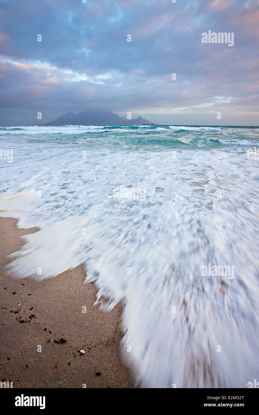 View from the beach at Bloubergstrand over the ocean with a classic view of Table Mountain across the bay. Stock Photo