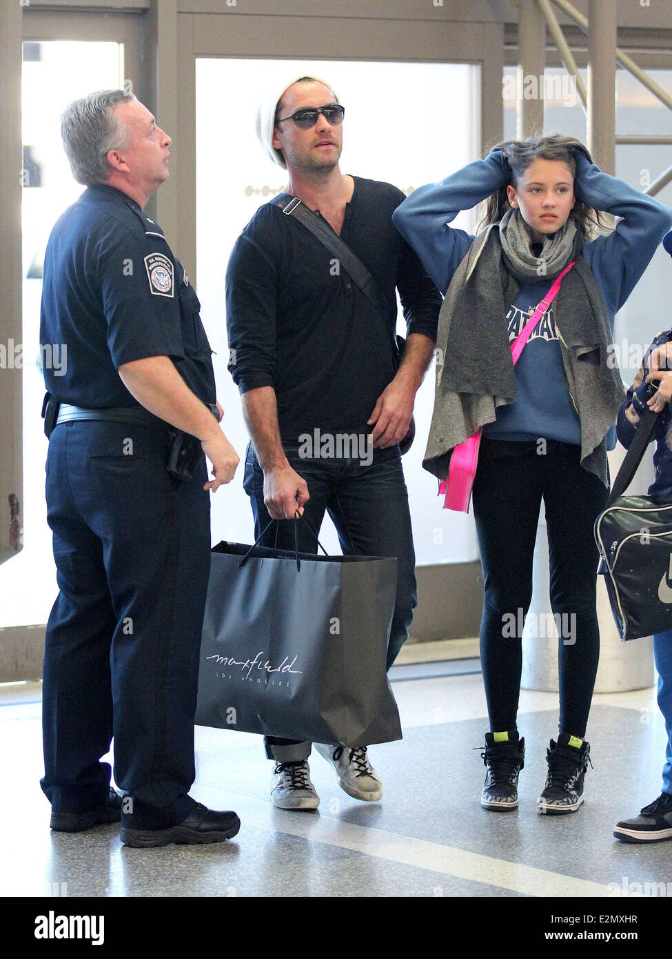 Jude Law with his daughter Iris and son Rudy arrive at Los Angeles International Airport, LAX looking tanned and relaxed after their holiday  Featuring: Jude Law,Iris Law Where: Los Angeles, California, USA When: 03 Jan 2013 Stock Photo