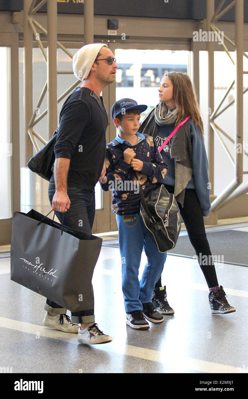Jude Law with his daughter Iris and son Rudy arrive at Los Angeles International Airport, LAX looking tanned and relaxed after their holiday  Featuring: Jude Law,Iris Law,Rudy Law Where: Los Angeles, California, USA When: 03 Jan 2013 Stock Photo