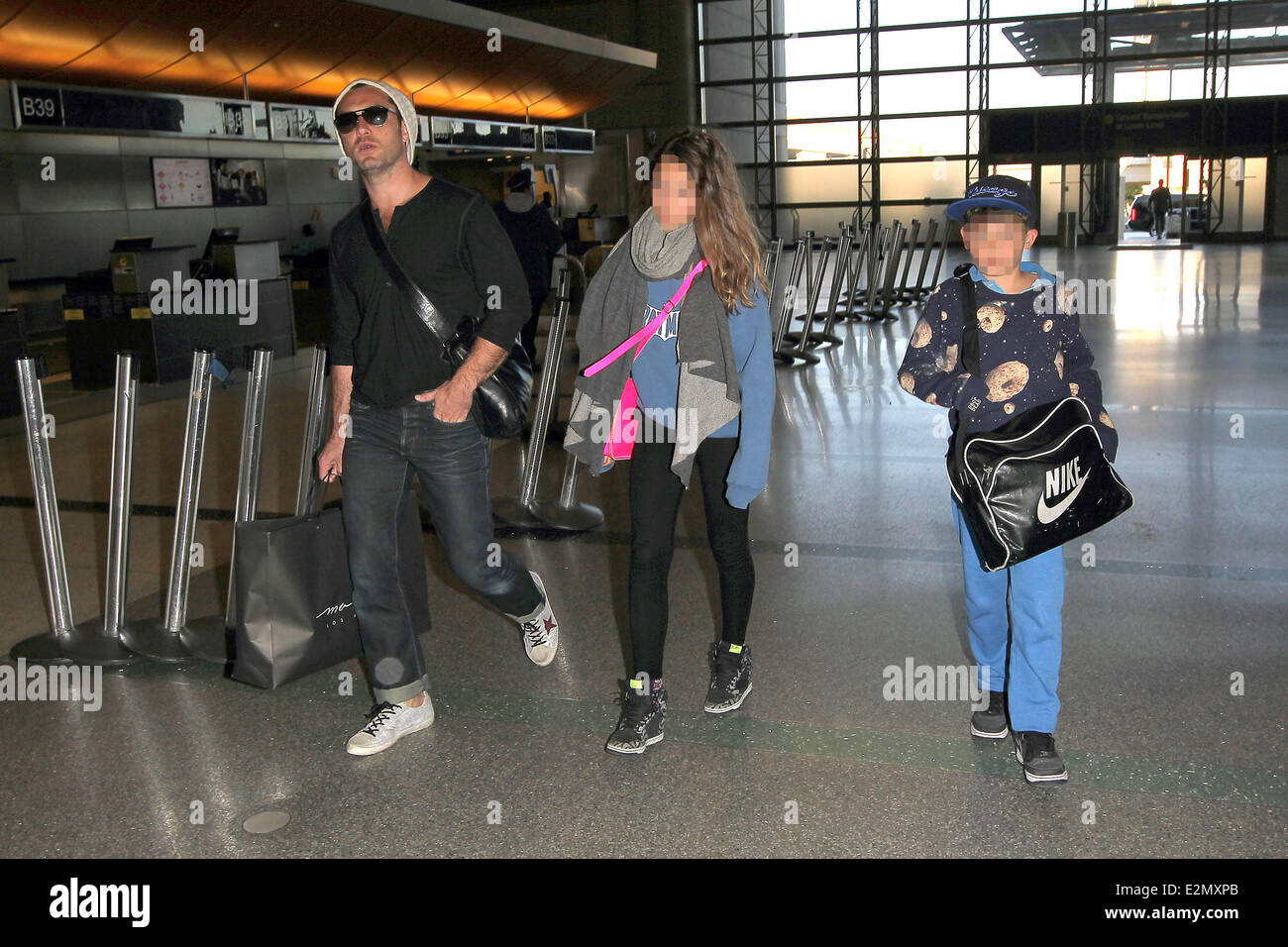 Jude Law with his daughter Iris and son Rudy arrive at Los Angeles International Airport, LAX looking tanned and relaxed after their holiday  Featuring: Jude Law,Rudy Law,Iris Law Where: Los Angeles, California, United States When: 03 Jan 2013 Stock Photo