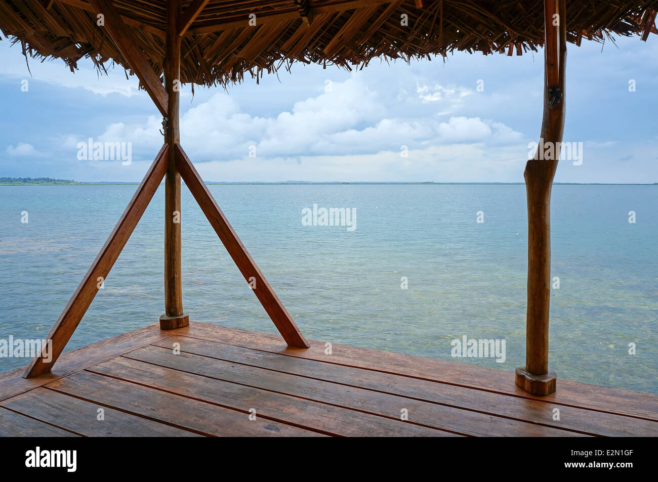 Calm sea from a palapa over water with cloud at the horizon Stock Photo