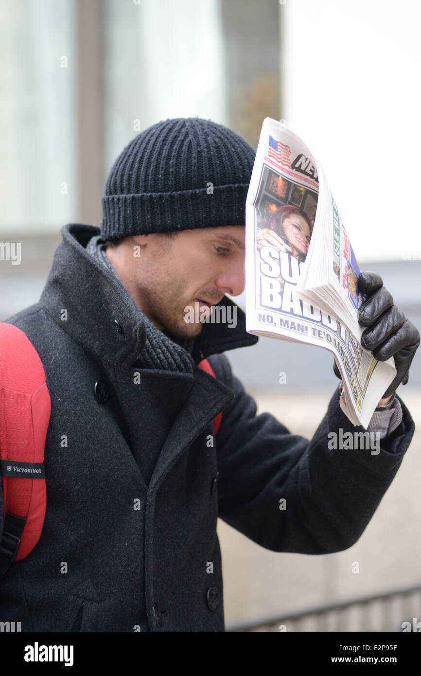 Jason Hoppy shields his face with The New York Post while out and about