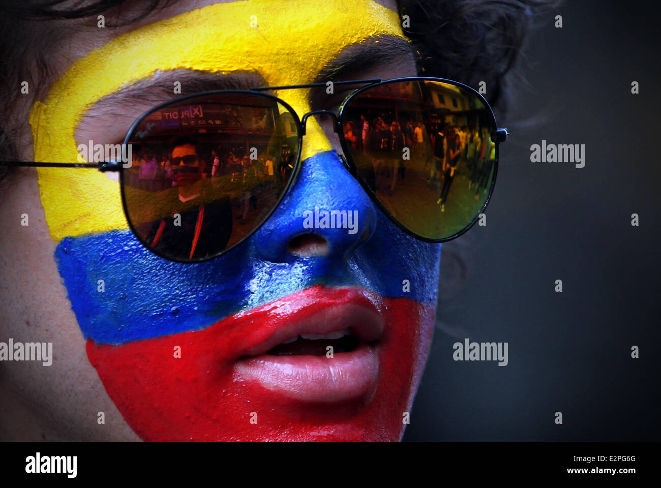 Quito, Ecuador. 20th June, 2014. An Ecuadorian fan with the face painted takes part in the celebration of the victory of the Ecuador National Soccer Team against Honduras in the Group E match of the second round of 2014 FIFA World Cup, at the Foch Square, in Quito, capital of Ecuador, on June 20, 2014. Credit:  Santiago Armas/Xinhua/Alamy Live News Stock Photo
