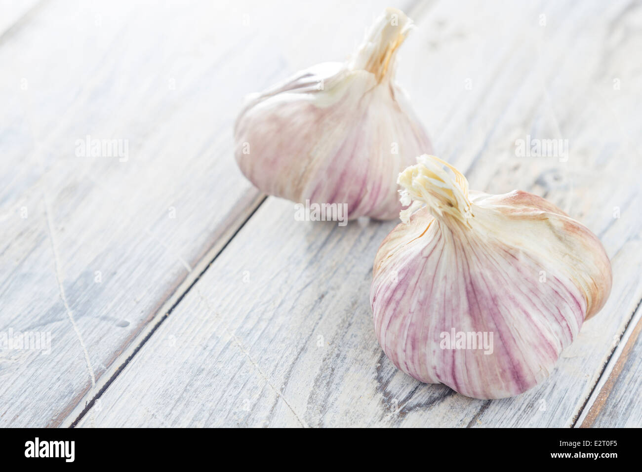two garlic cloves on a wooden table Stock Photo - Alamy