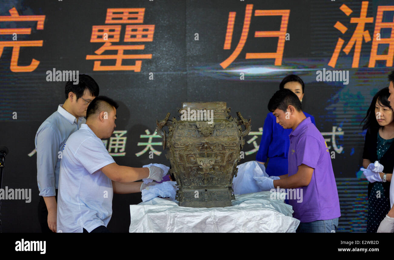 (140621) -- CHANGSHA, June 21, 2014 (Xinhua) -- Staff members re-pack the Min Fanglei at the airport of Changsha, capital of central China's Hunan Province, June 21, 2014. Lei was a kind of ritual vessel and wine container in the late Shang Dynasty (1600 BC-1046 BC) and early Zhou Dynasty (1046 BC - 771 BC) in China. The Min Fanglei, which got its name Min from the inscriptions on it, is the most exquisite and largest Lei ever unearthed. The body of Min Fanglei has been separated from its lid since its was unearthed in 1919 in Taoyuan County of Hunan. The famous bronzeware, which has been away Stock Photo