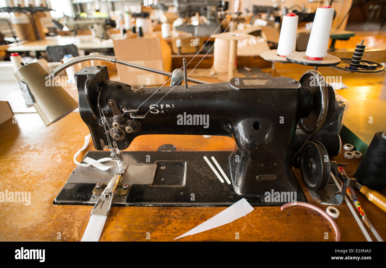 A black, Singer sewing machine attached to an antique table sits in a corset factory in Cortland, NY. Stock Photo