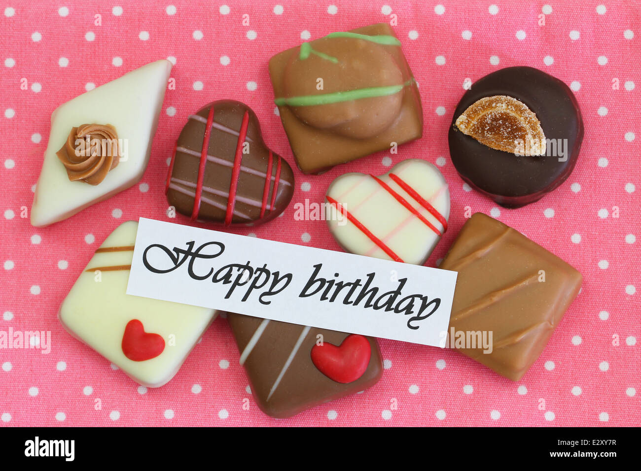 Happy Birthday card with selection of chocolates on pink background ...