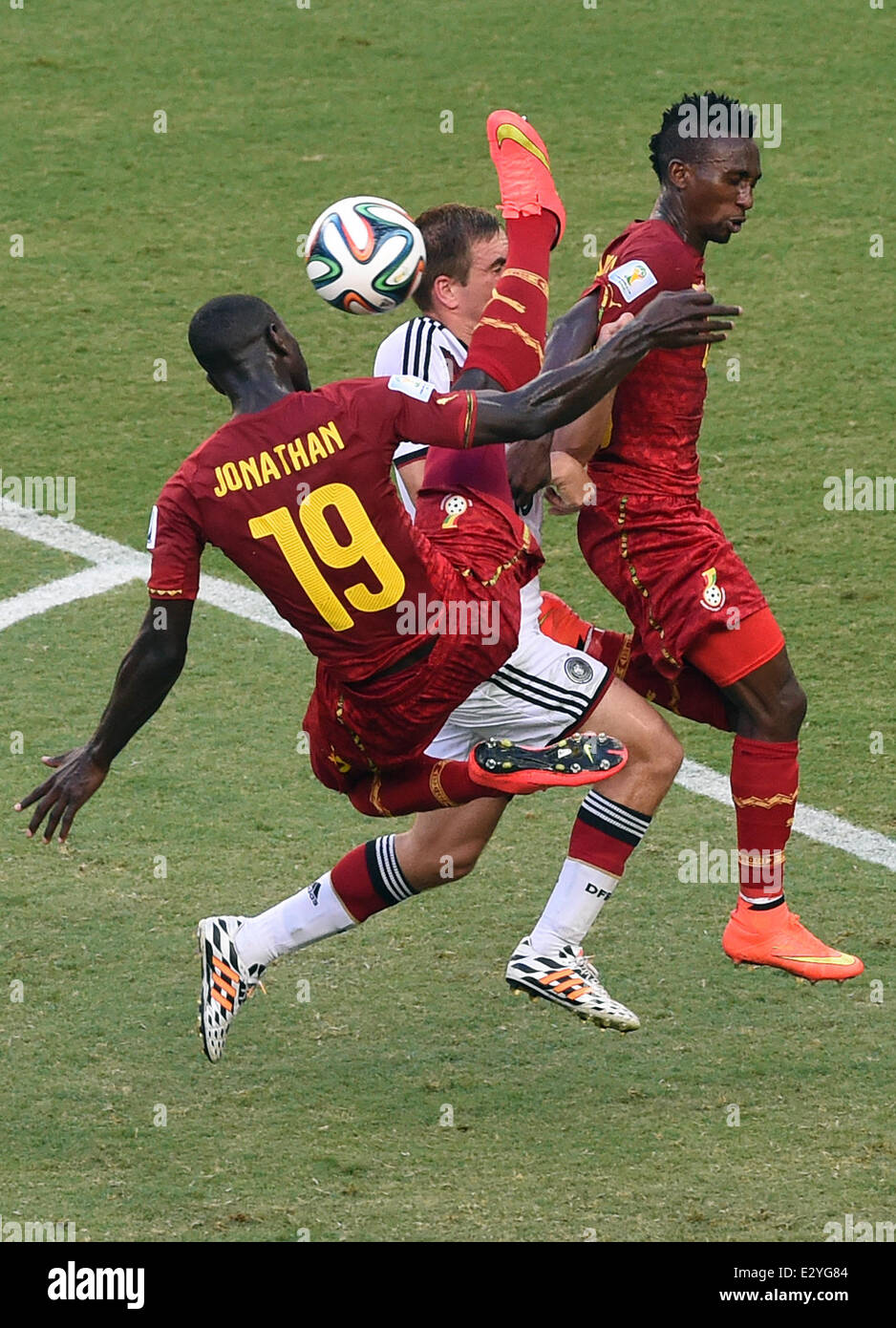 Fortaleza, Brazil. 21st June, 2014. Ghana's Jonathan Mensah (L-R), Germany's Philipp Lahm and Ghana's Harrison Afful vie for the ball during the FIFA World Cup 2014 group G preliminary round match between Germany and Ghana at the Estadio Castelao Stadium in Fortaleza, Brazil, 21 June 2014. Photo: Marcus Brandt/dpa/Alamy Live News Stock Photo