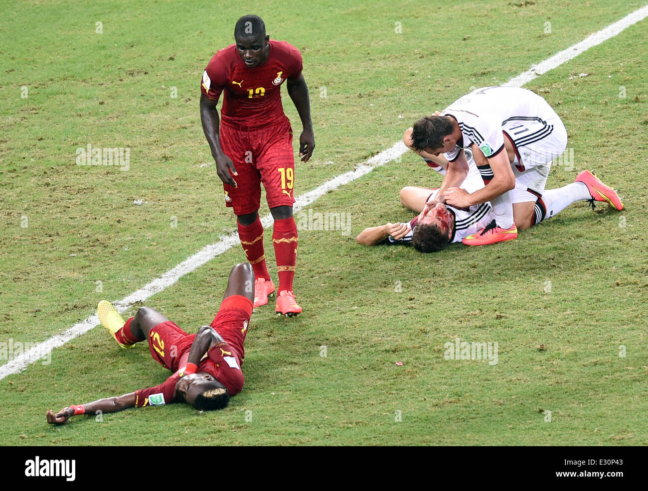 Fortaleza, Brazil. 21st June, 2014. Miroslav Klose (R) of Germany assists injured teammate Thomas Mueller as Ghana's Jonathan Mensah (2-L) assists injured teammate John Boye (L) during the FIFA World Cup 2014 group G preliminary round match between Germany and Ghana at the Estadio Castelao Stadium in Fortaleza, Brazil, 21 June 2014. Photo: Marcus Brandt/dpa/Alamy Live News Stock Photo