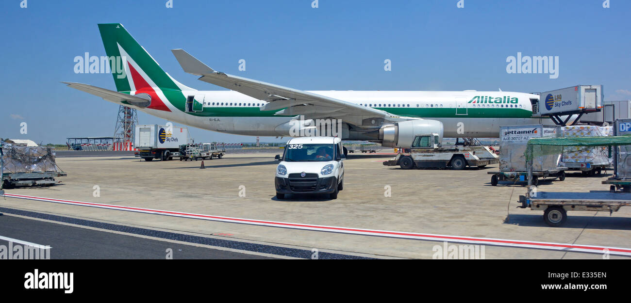 Italian Alitalia Airbus A330 220 jet airplane aircraft tail fin logo view at Rome Fiumicino Italy international airport apron stand ground crew attend Stock Photo