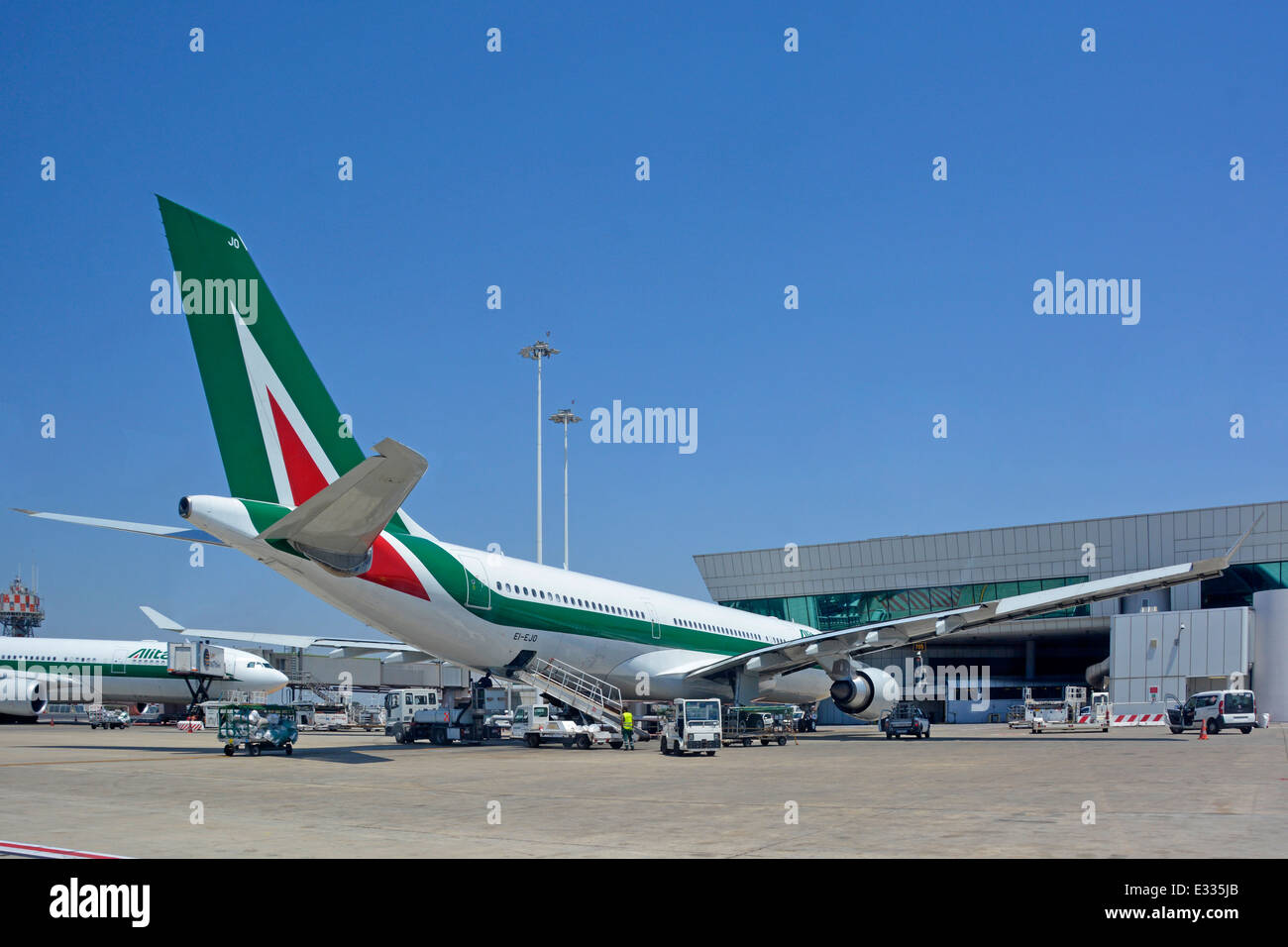 Italian Alitalia Airbus A330 220 jet airplane aircraft tail fin logo view at Rome Fiumicino Italy international airport apron stand ground crew attend Stock Photo