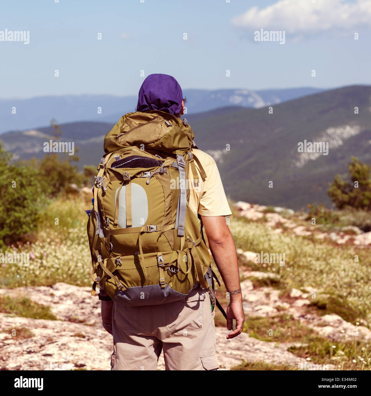 Hiker with backpack standing on top of a mountain Stock Photo - Alamy