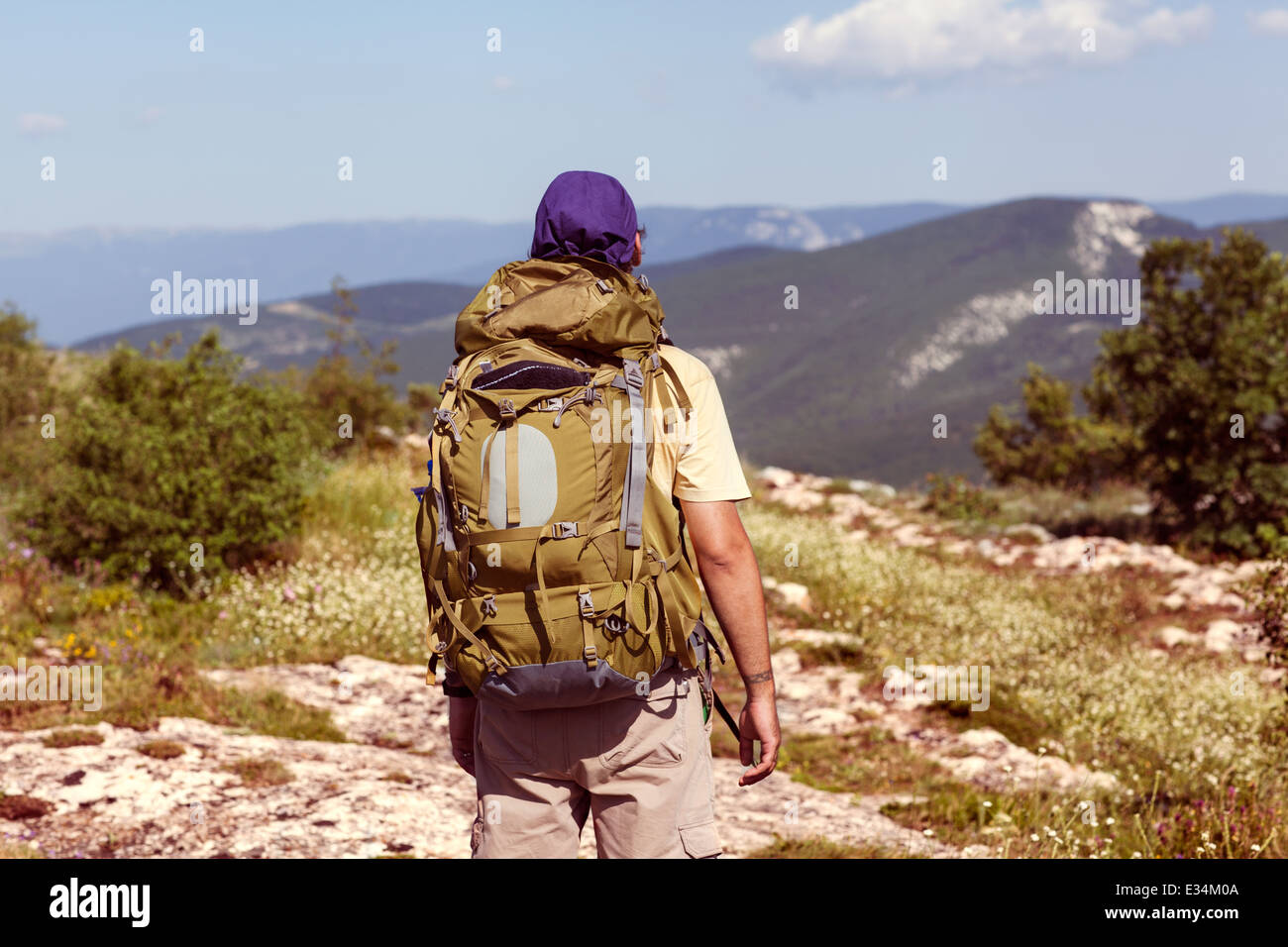 Hiker with backpack standing on top of a mountain Stock Photo - Alamy