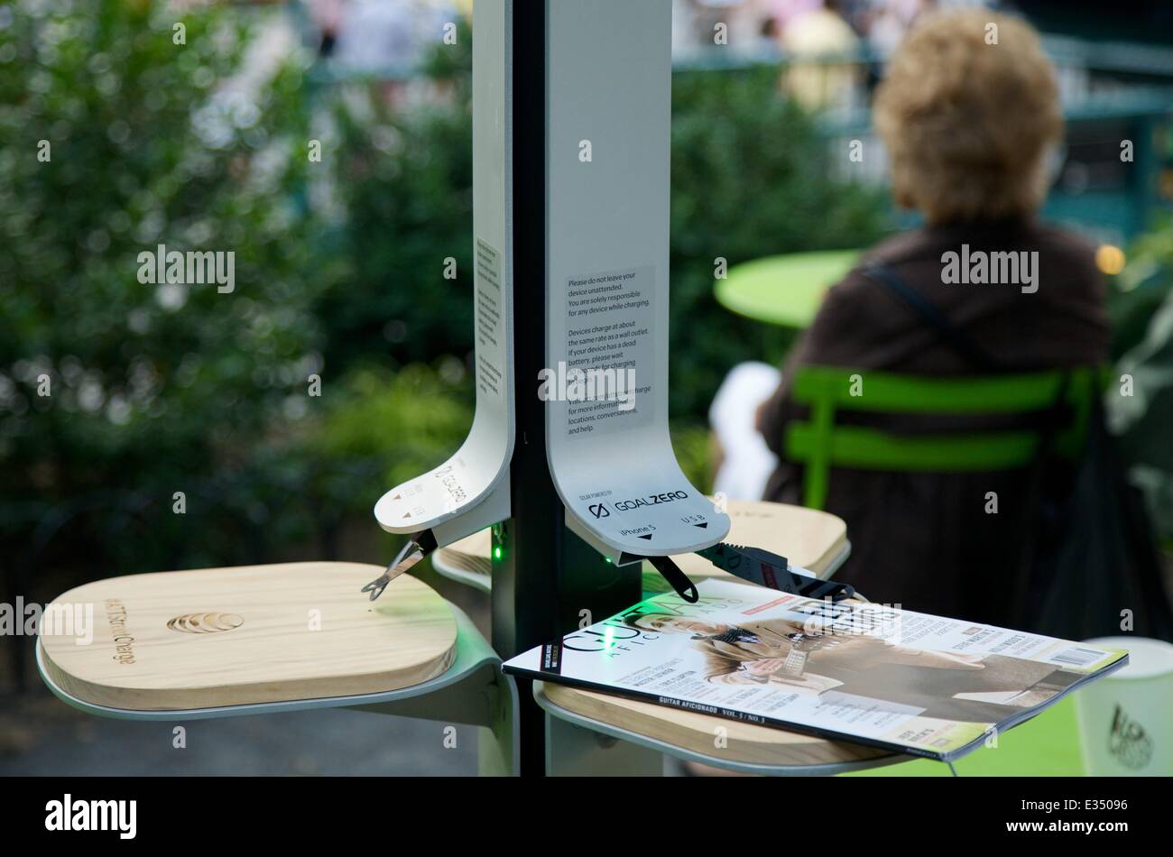 AT&T introduce solar-powered charging stations to New Yorkers. As keeping the mobile life going becomes ever more important  both to wireless customers and the providers who serve them AT&T says it has a new way to keep New Yorkers connected free. 12.5-foot steel poles with three petal-shaped solar panels fanning out on top can accommodate up to six devices at a time regardless of wireless carrier, with dedicated ports for iPhones, Androids, BlackBerrys and standard USB charging cables. Designed by a Dumbo-based firm, Pensa, with solar technology from Goal Zero, a mobile solar start-up, they a Stock Photo