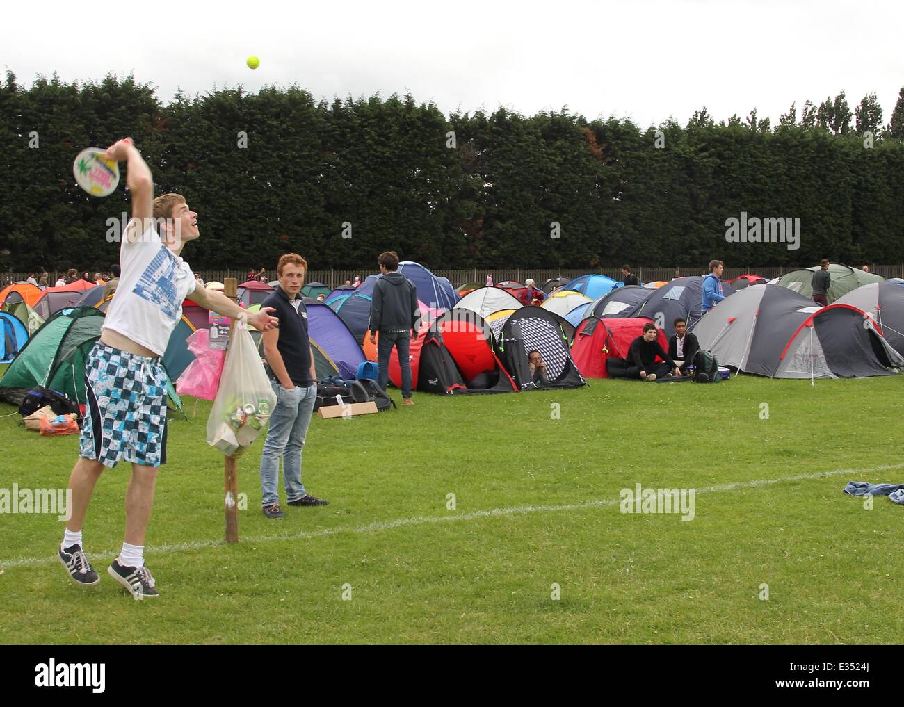 Tennis fans camp out at Wimbledon ahead of the opening day of the 2013 All England Lawn Tennis Championships. Some campers pass the time by playing their own form of tennis on the playing fields opposite.  Where: London, United Kingdom When: 23 Jun 2013 Stock Photo