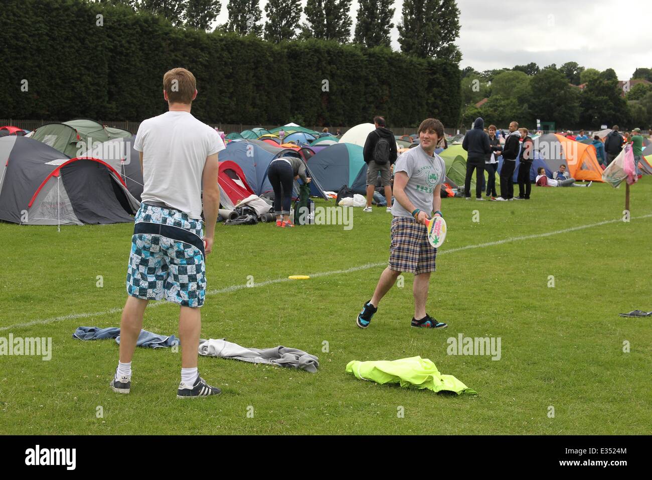 Tennis fans camp out at Wimbledon ahead of the opening day of the 2013 All England Lawn Tennis Championships. Some campers pass the time by playing their own form of tennis on the playing fields opposite.  Where: London, United Kingdom When: 23 Jun 2013 Stock Photo