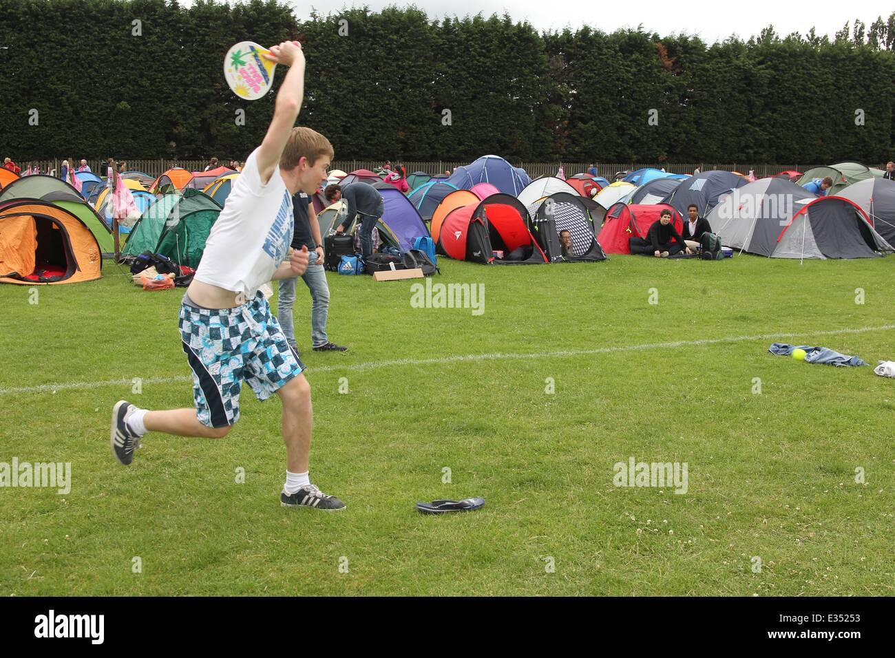 Tennis fans camp out at Wimbledon ahead of the opening day of the 2013 All England Lawn Tennis Championships. Some campers pass the time by playing their own form of tennis on the playing fields opposite.  Where: London, United Kingdom When: 23 Jun 2013 Stock Photo