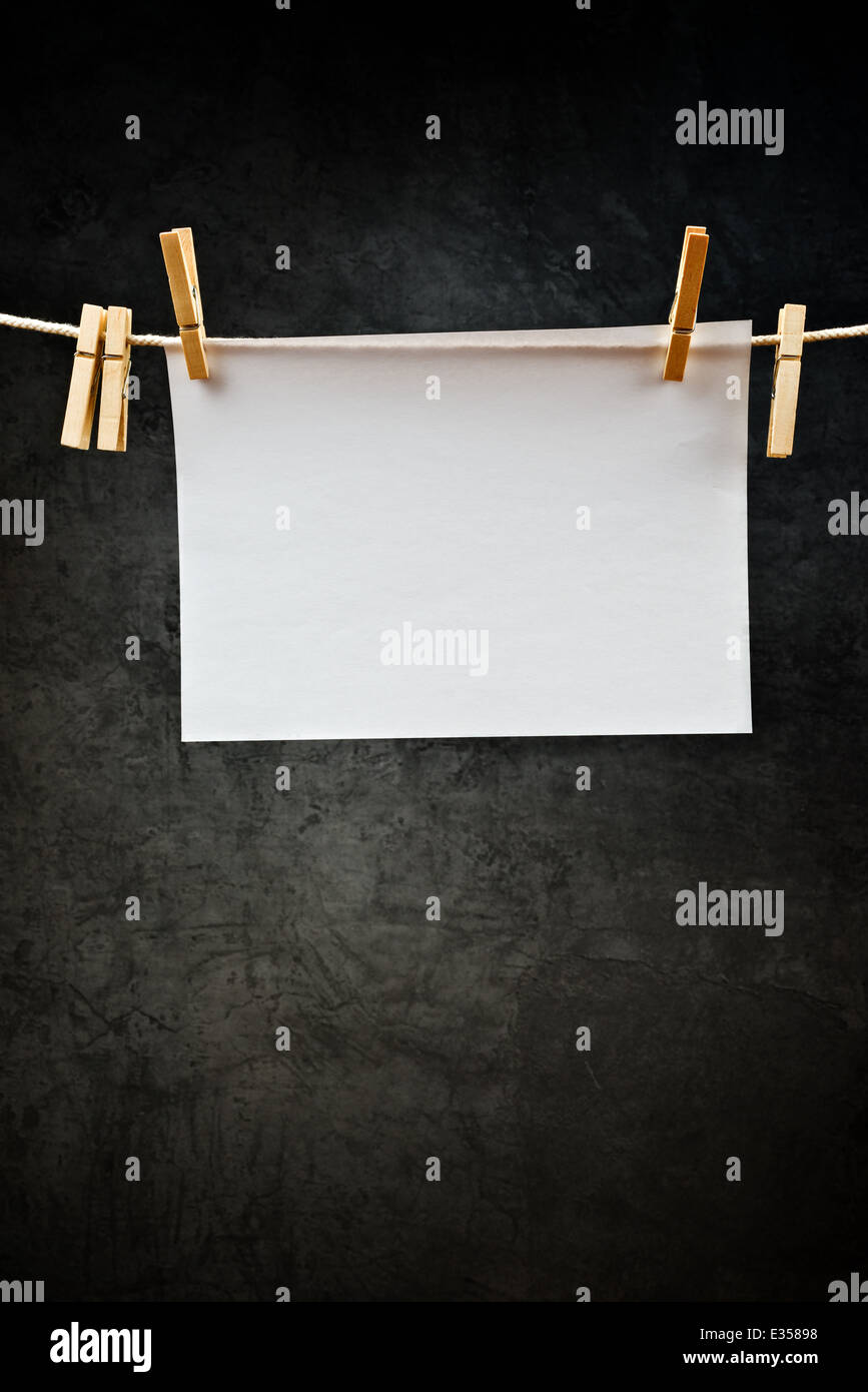 Blank note paper hanging on rope with clothes pins, copy space for your text or image or product placement. Stock Photo