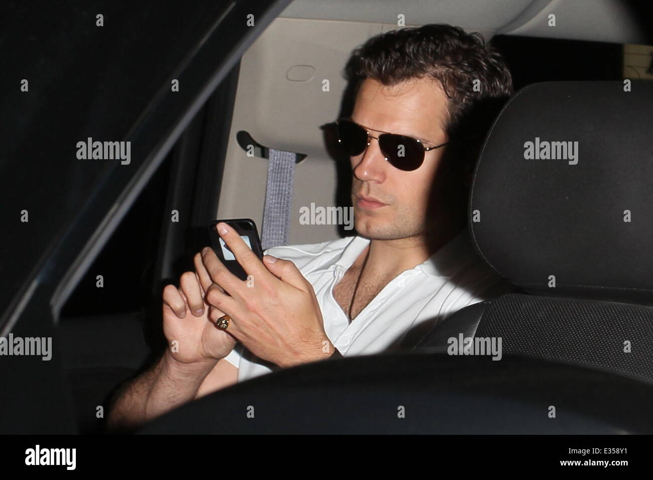 'Man of Steel' actor Henry Cavill is seen arriving at LAX Airport. Whilst using his mobile phone a Superman Insignia is visible on the rear of the device.  Featuring: Henry Cavill Where: Los Angeles, CA, United States When: 26 Jun 2013 Stock Photo