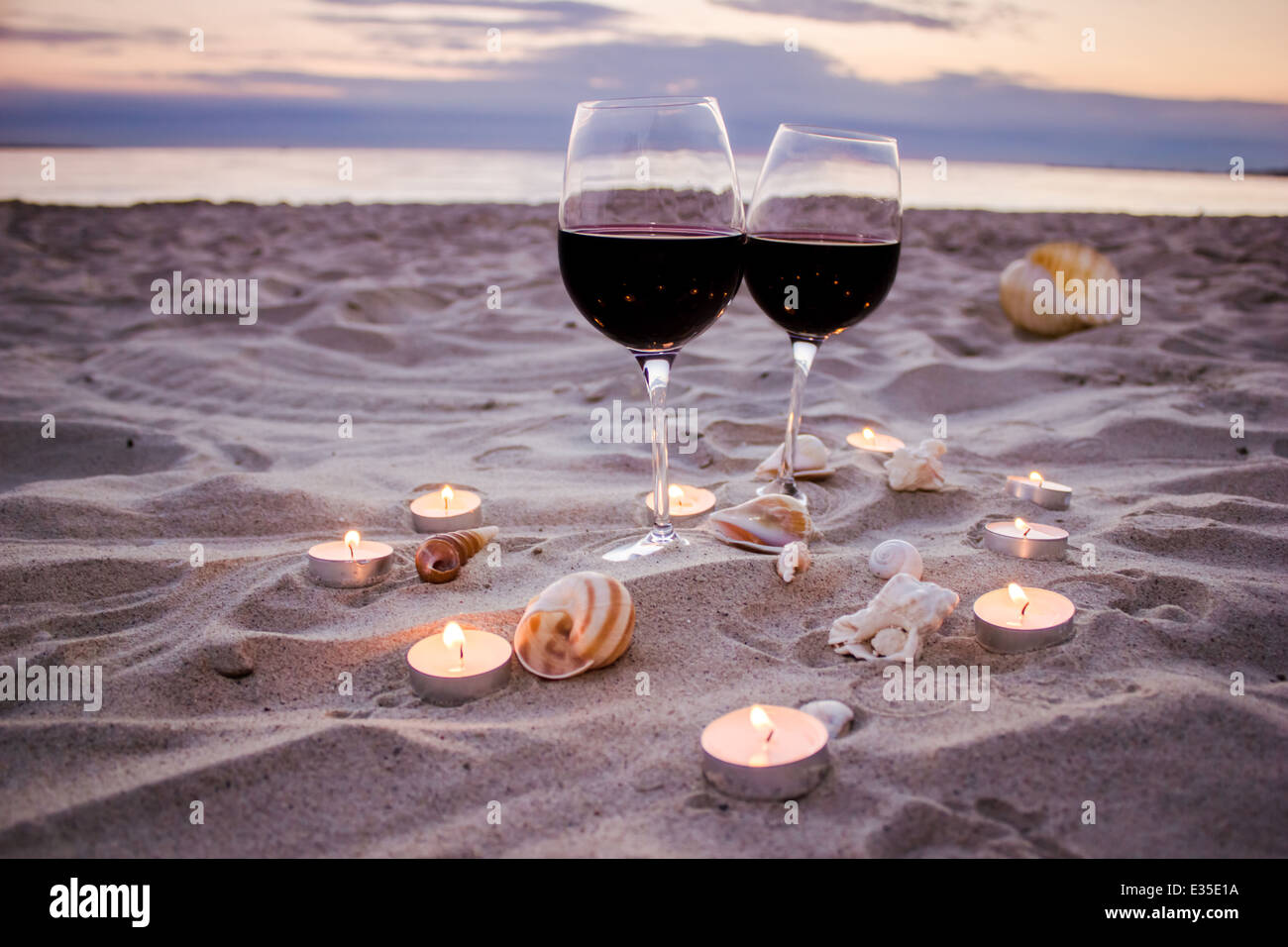 Romantic beach evening on the sunset two glasses of wine, candles, shells, valentines day Stock