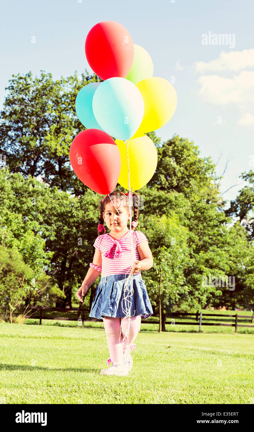 Little child in the park holding balloons Stock Photo - Alamy