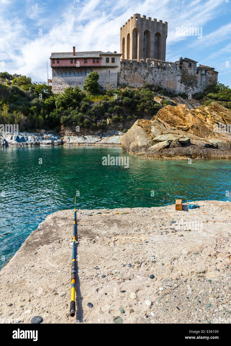 Abandoned fishing rod next to Megisti Lavra port (arsanas) in Holy Mount Athos in Greece with guesthouse in the background Stock Photo