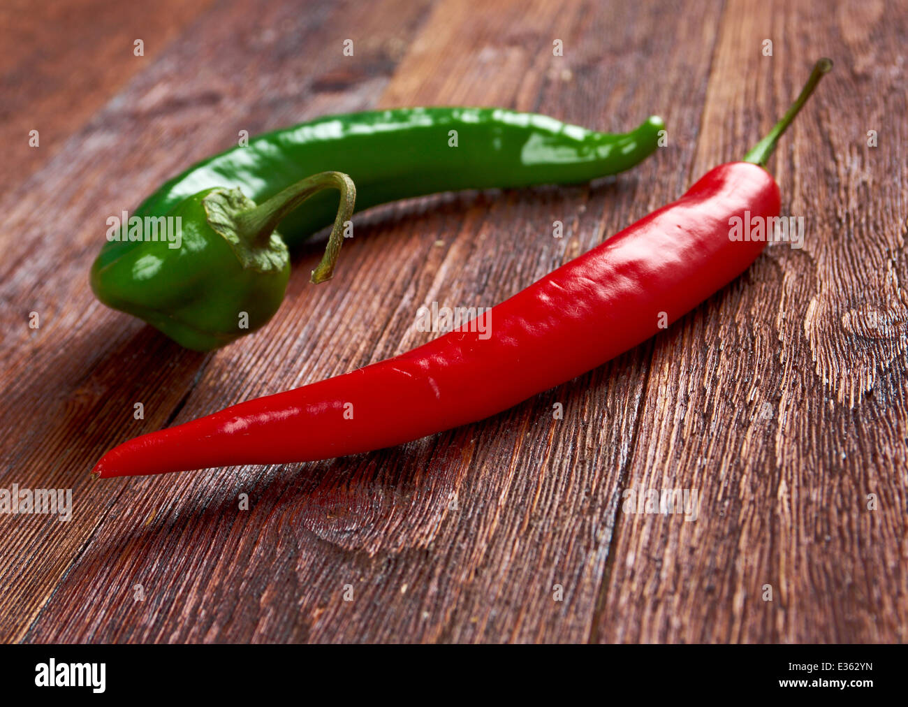 Red and green Hot Chili Peppers over wooden background Stock Photo - Alamy
