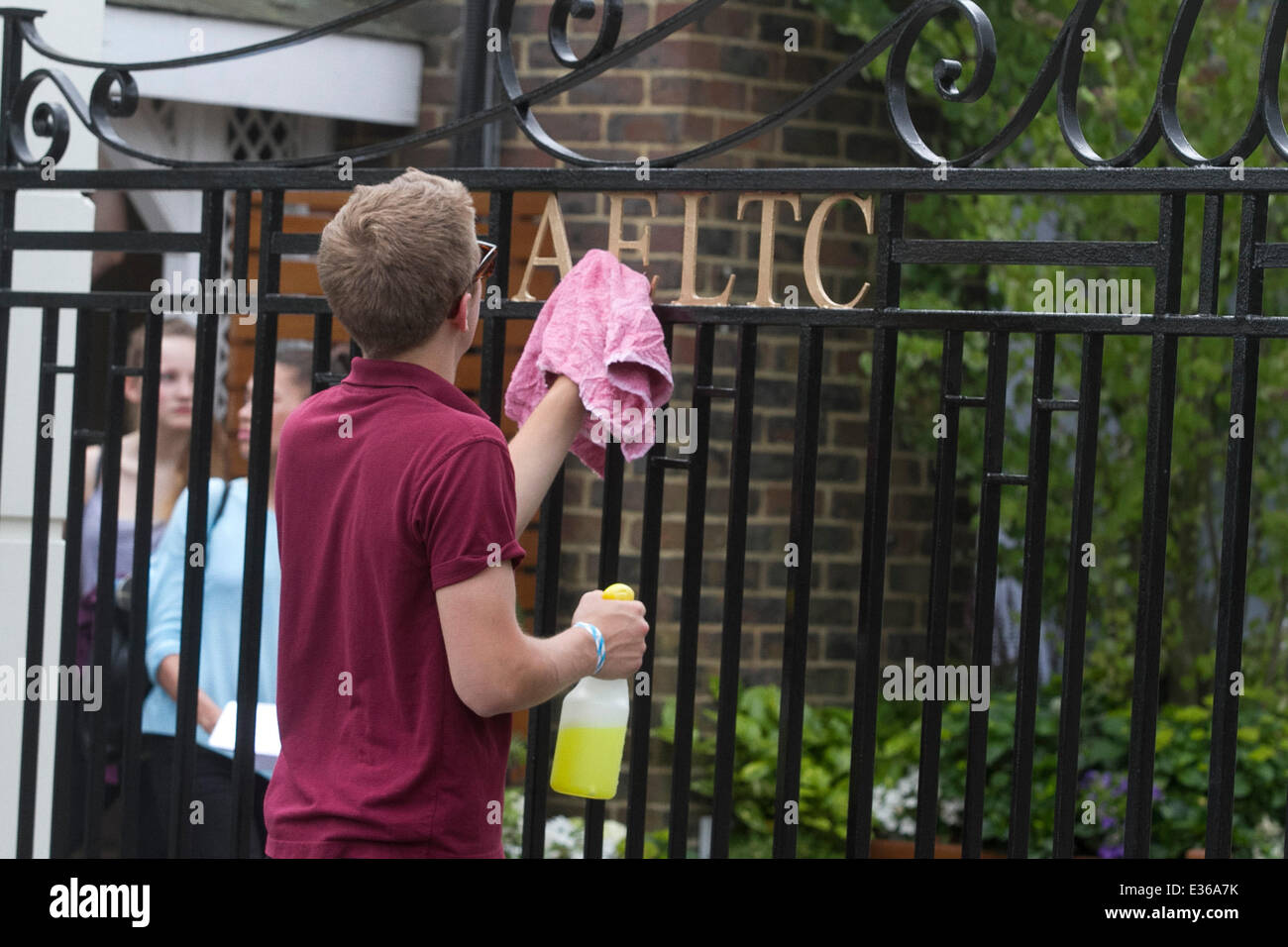 Wimbledon, London, UK. 22nd June, 2014. Staff members cleaning the entrance gate of the (AELTC ) All England Lawn Tennis Club ahead of the 2014 Wimbledon Lawn tennis championships which starts on Monday 23 June. Stock Photo