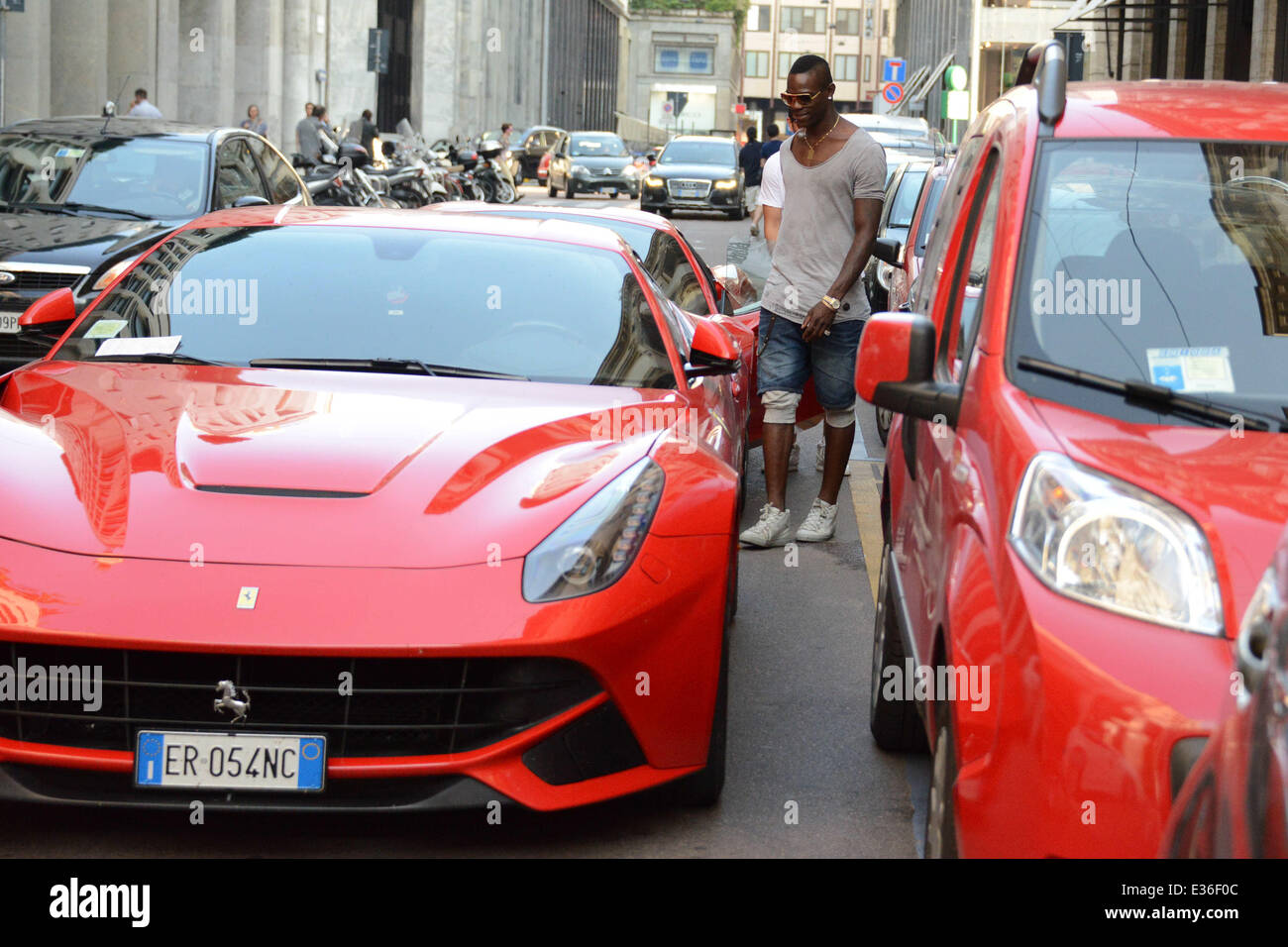 Italian football star Mario Balotelli and a friend return to their Ferrari's  after a quick visit to a Louis Vuitton store in Milan Featuring: View,Mario  Balotelli new Ferrari Where: Milan, Italy When: