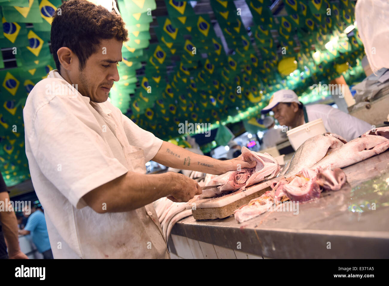 Manaus, Brazil. 22nd June, 2014. A Brazilian fresh fish-seller cuts fish at a fish and food market in Manaus, Brazil, 22 June 2014. Portugal faces the USA in a FIFA World Cup 2014 group G preliminary round match in Manaus on 22 June. Photo: Marius Becker/dpa/Alamy Live News Stock Photo