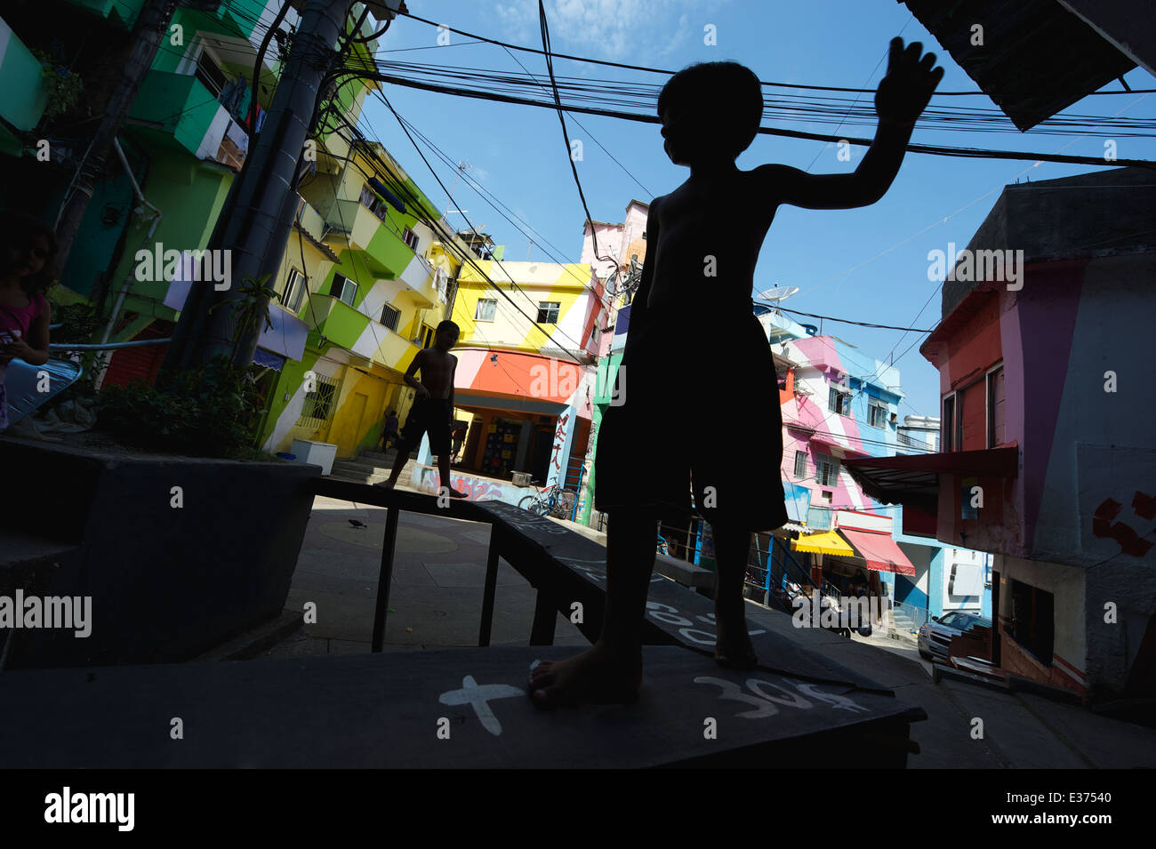 RIO DE JANEIRO, BRAZIL - FEBRUARY 14, 2014: Silhouettes of children play at colorful painted buildings Favela Dona Marta Stock Photo