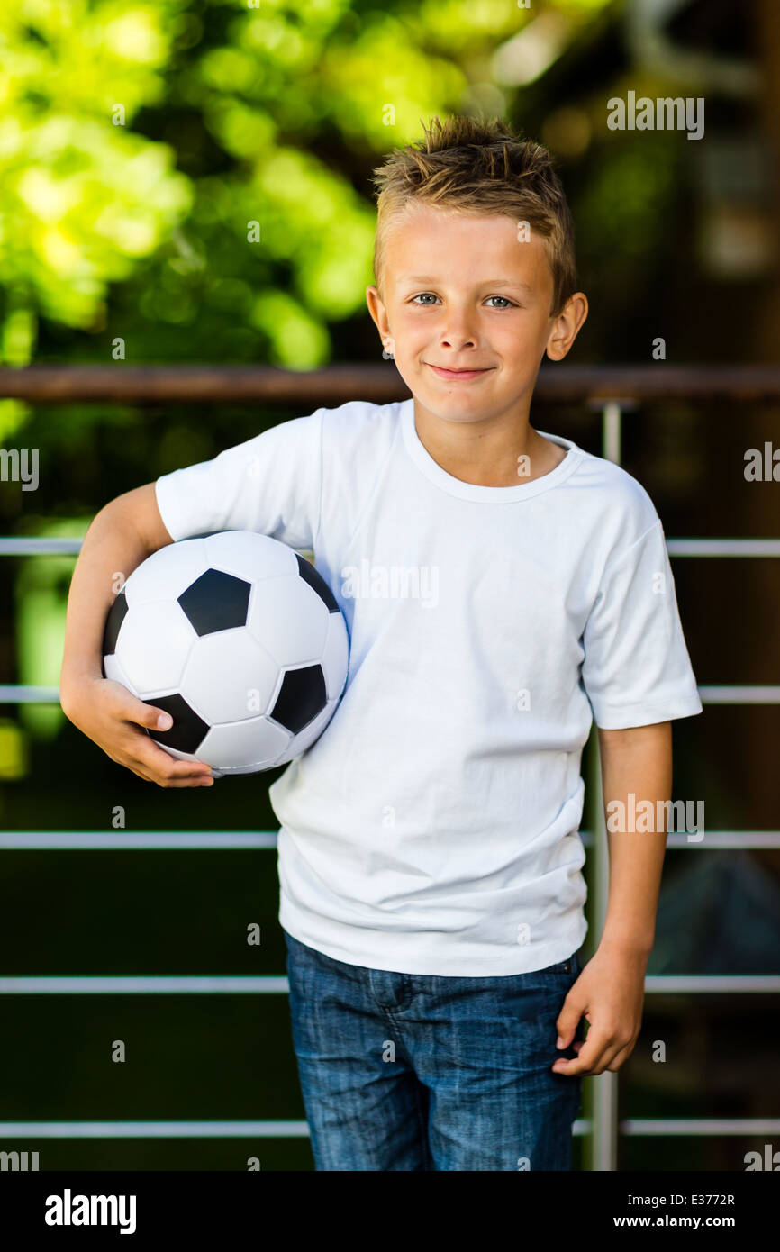 Caucasian boy holding his soccer ball under his right arm Stock Photo