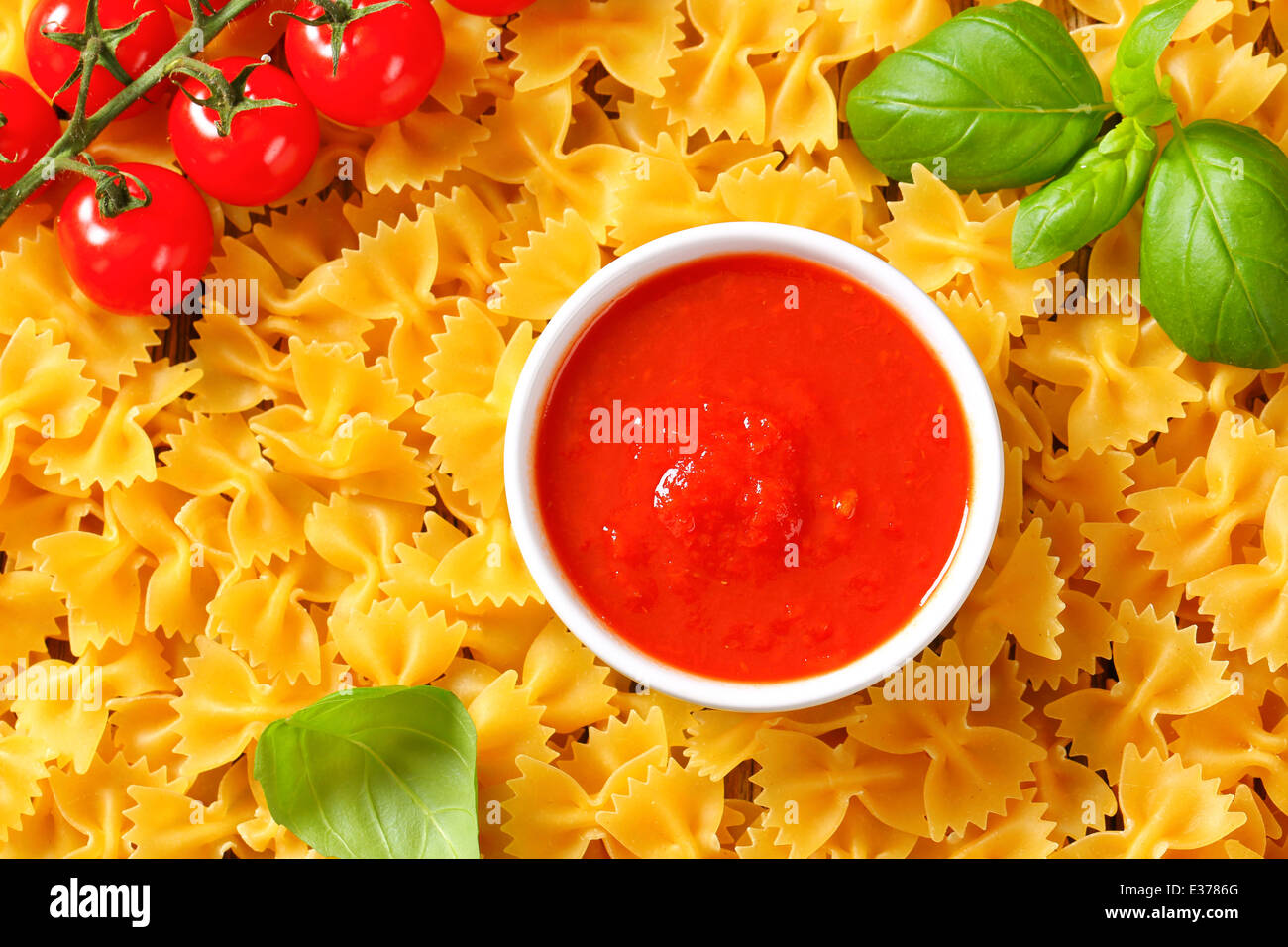 Uncooked bow tie pasta and tomato puree Stock Photo