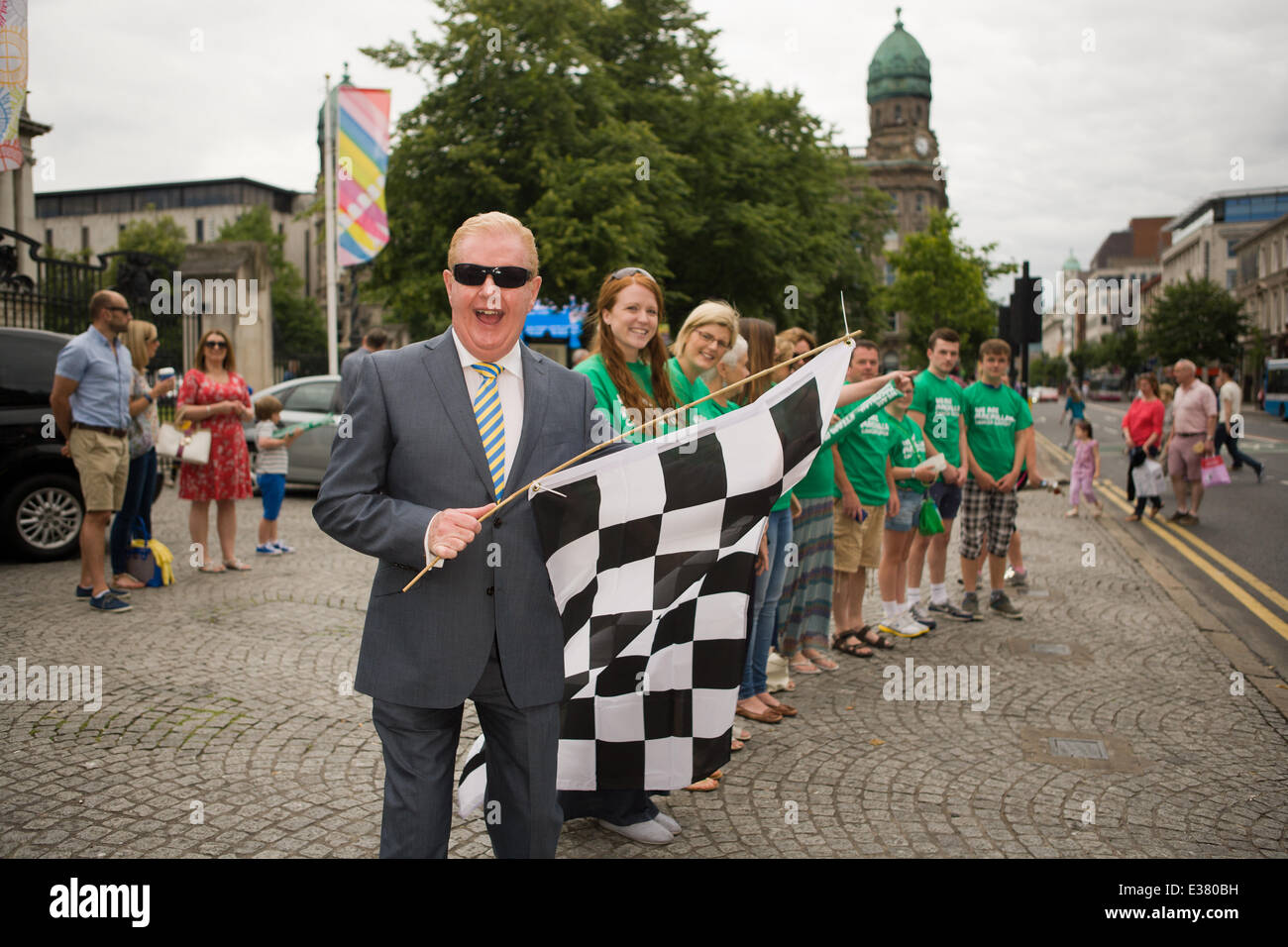 Belfast City Hall,UK. 22nd June 2014. Celebrity Julian Simmons with checkered flag at the finish line of the 6 Marathons in 6 Countries in 6 Days. Macmillan Cancer support was the Charity fior the runners who took part Stock Photo