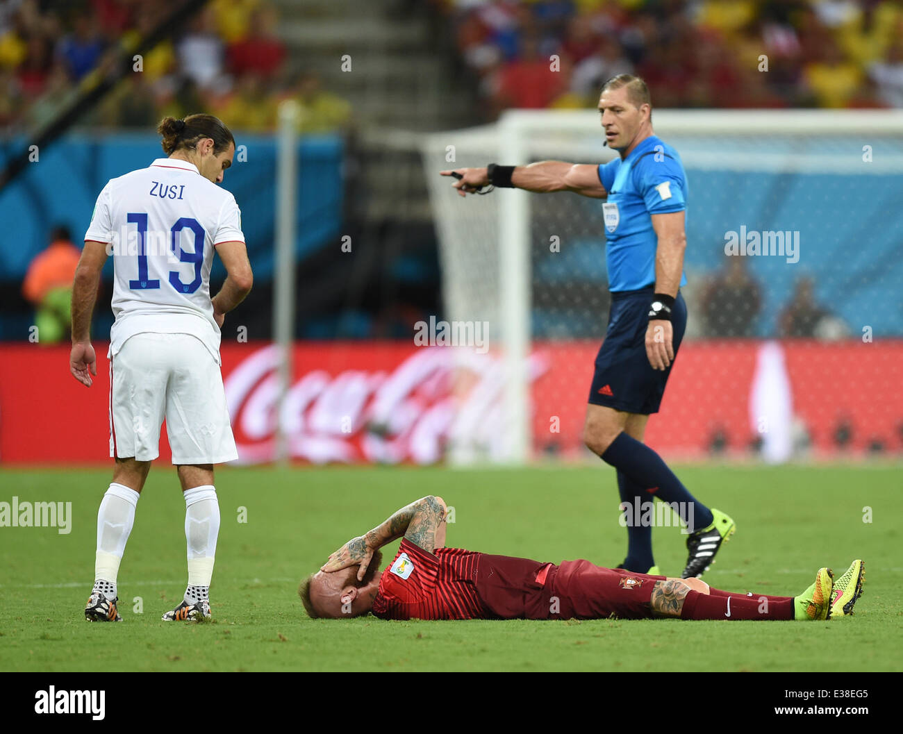 Manaus, Brazil. 22nd June, 2014. Raul Meireles of Portugal lies on the pitch next to Graham Zusi (L) of USA and referee Nestor Pitana (R) of Argentina after picking up an injury during the FIFA World Cup 2014 group G preliminary round match between the USA and Portugal at the Arena Amazonia Stadium in Manaus, Brazil, 22 June 2014. Photo: Marius Becker/dpa/Alamy Live News Stock Photo