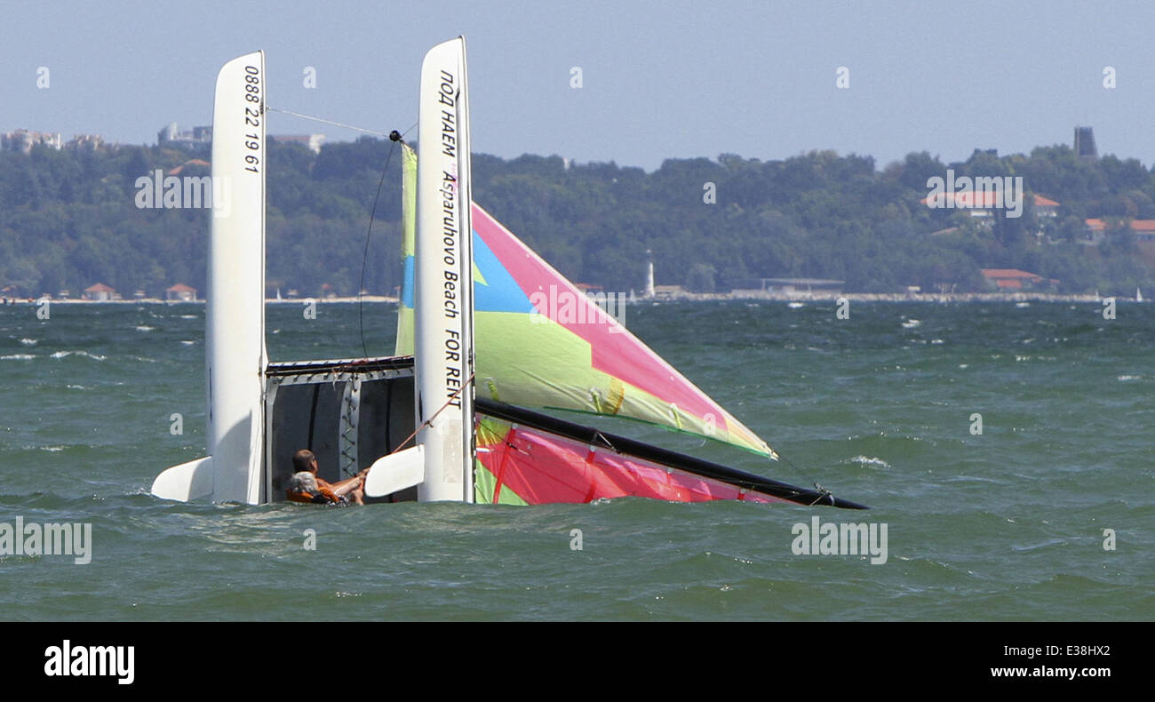 People watch at sinking catamaran yacht during a heavy wind storm at