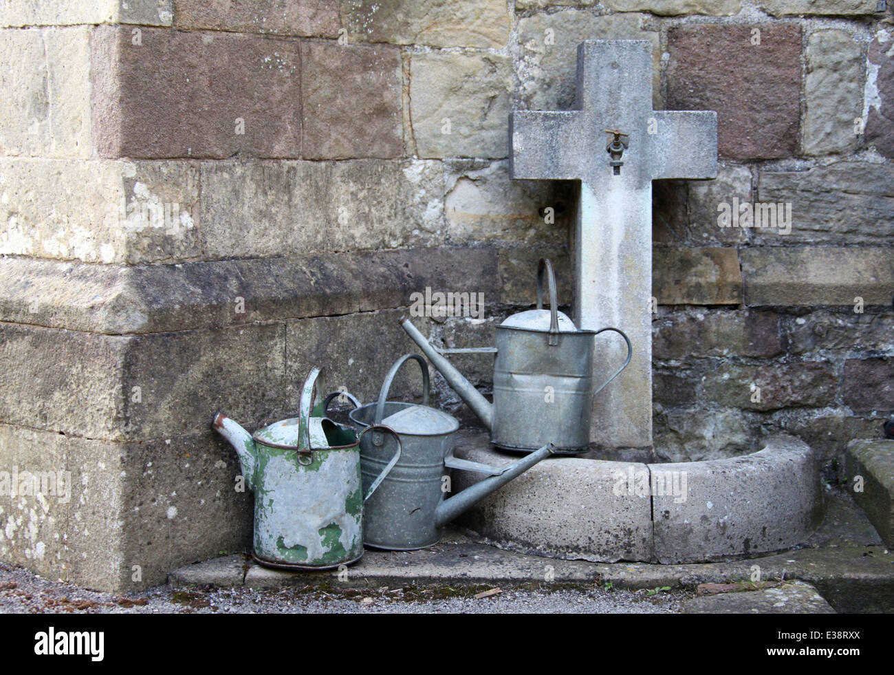 Churchyard Tap and Watering Cans in the Derbyshire Village of Bonsall Stock Photo