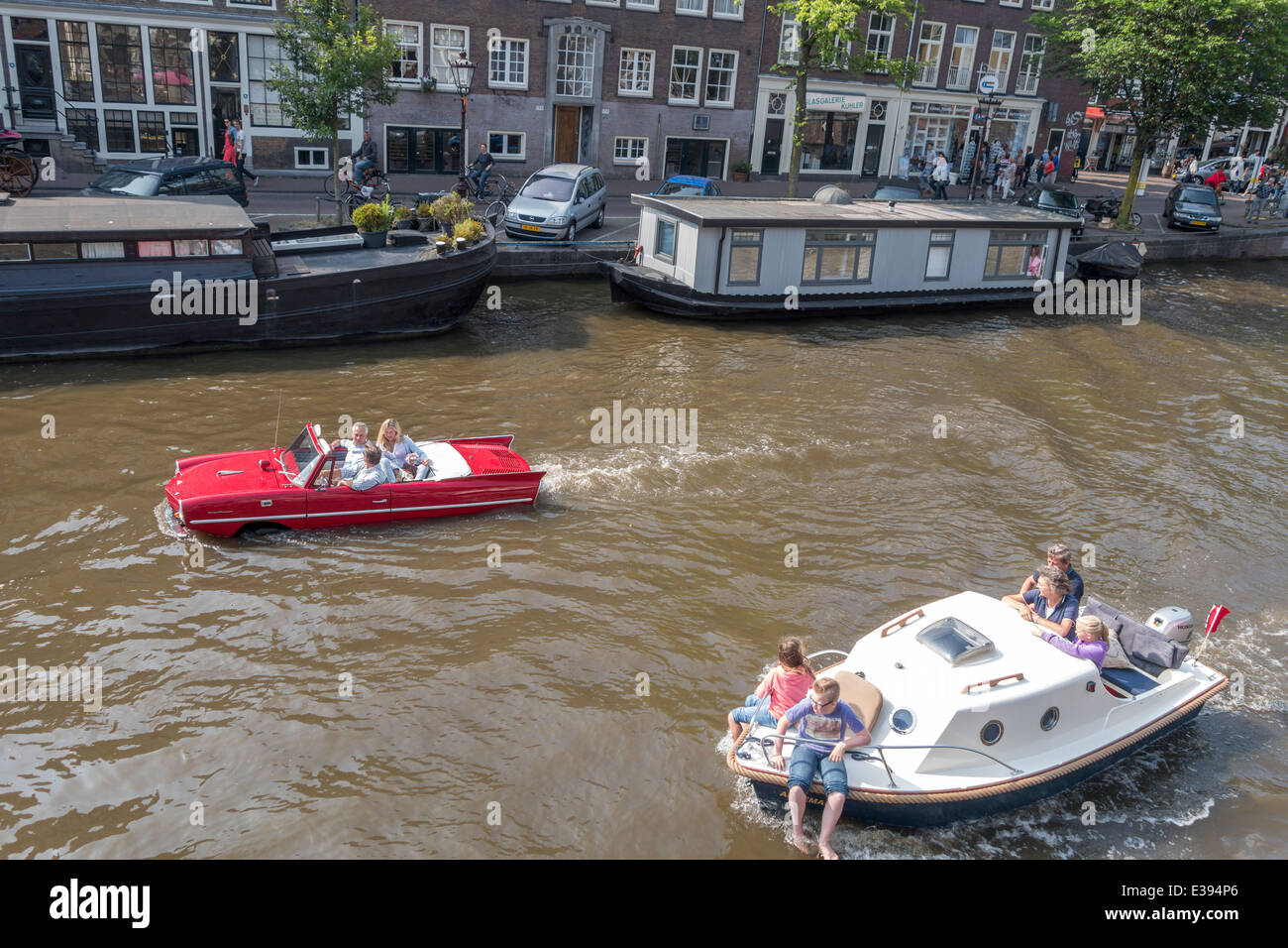 Vintage Amphicar 770 in the Prinsengracht an Amsterdam canal. Amphibious auto, water car, car boat with people. Stock Photo