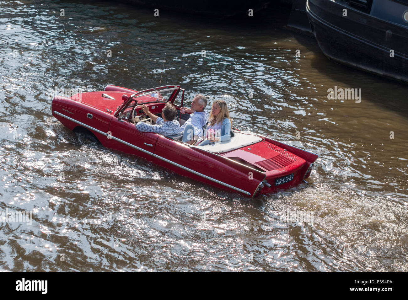 Vintage Amphicar 770 in an Amsterdam canal. Amphibious auto, water car, car boat with people. Stock Photo
