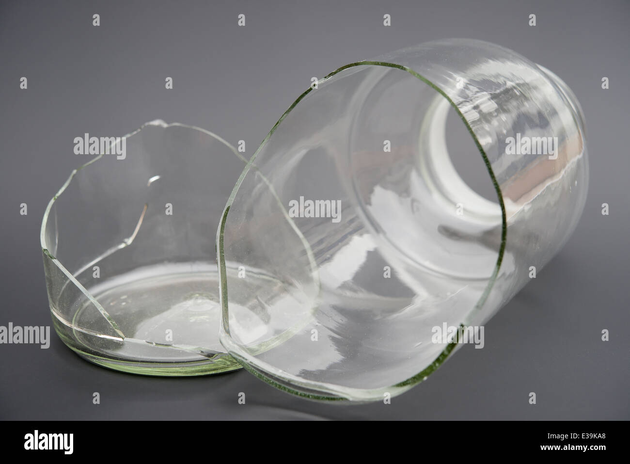broken glass container on a grey background Stock Photo Alamy