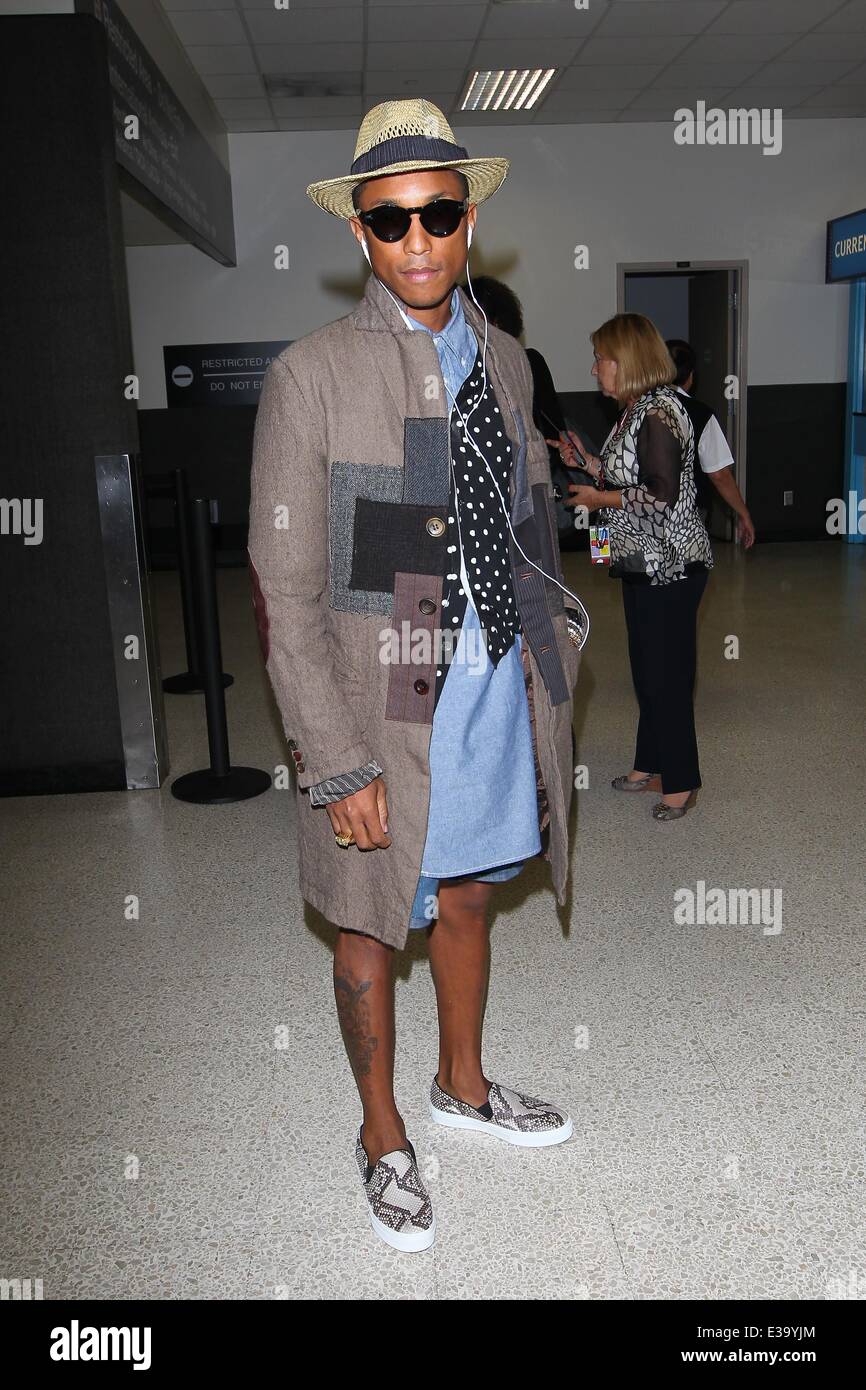 Pharrell Williams arrives at LAX in style. He wore a patchwork coat  complimented by a polka dot waistcoat with long tailed denim shirt. On his  feet he had snake skin slip-on sneakers