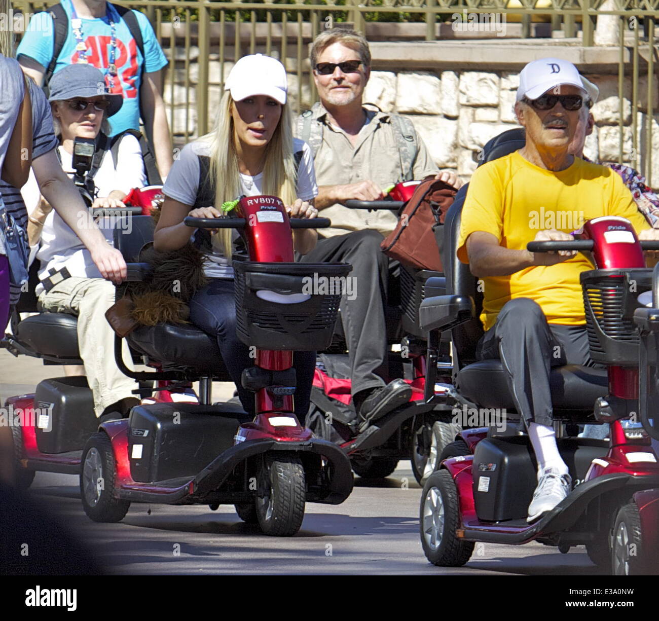 Hugh Hefner and Crystal Hefner ride mobility scooters through