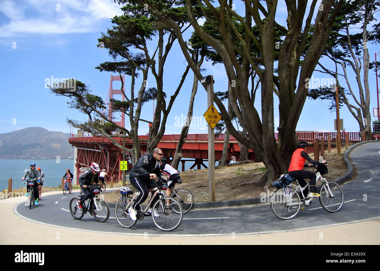 cyclists on rental bikes riding on bike path leading up to Golden Gate Bridge Stock Photo