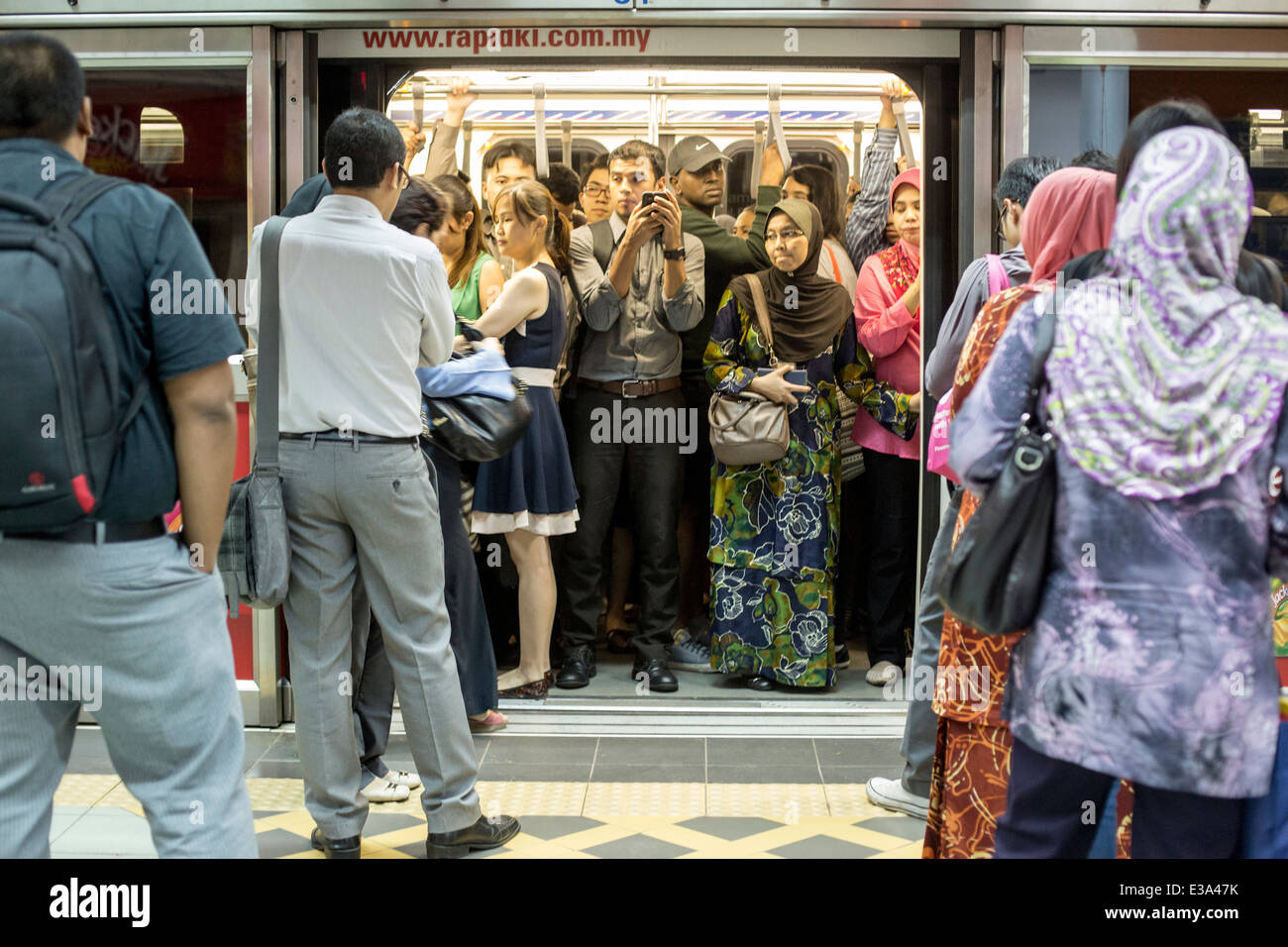 Commuters wait on a train at a RapidKL LRT station in Kuala Lumpur, Malaysia Stock Photo