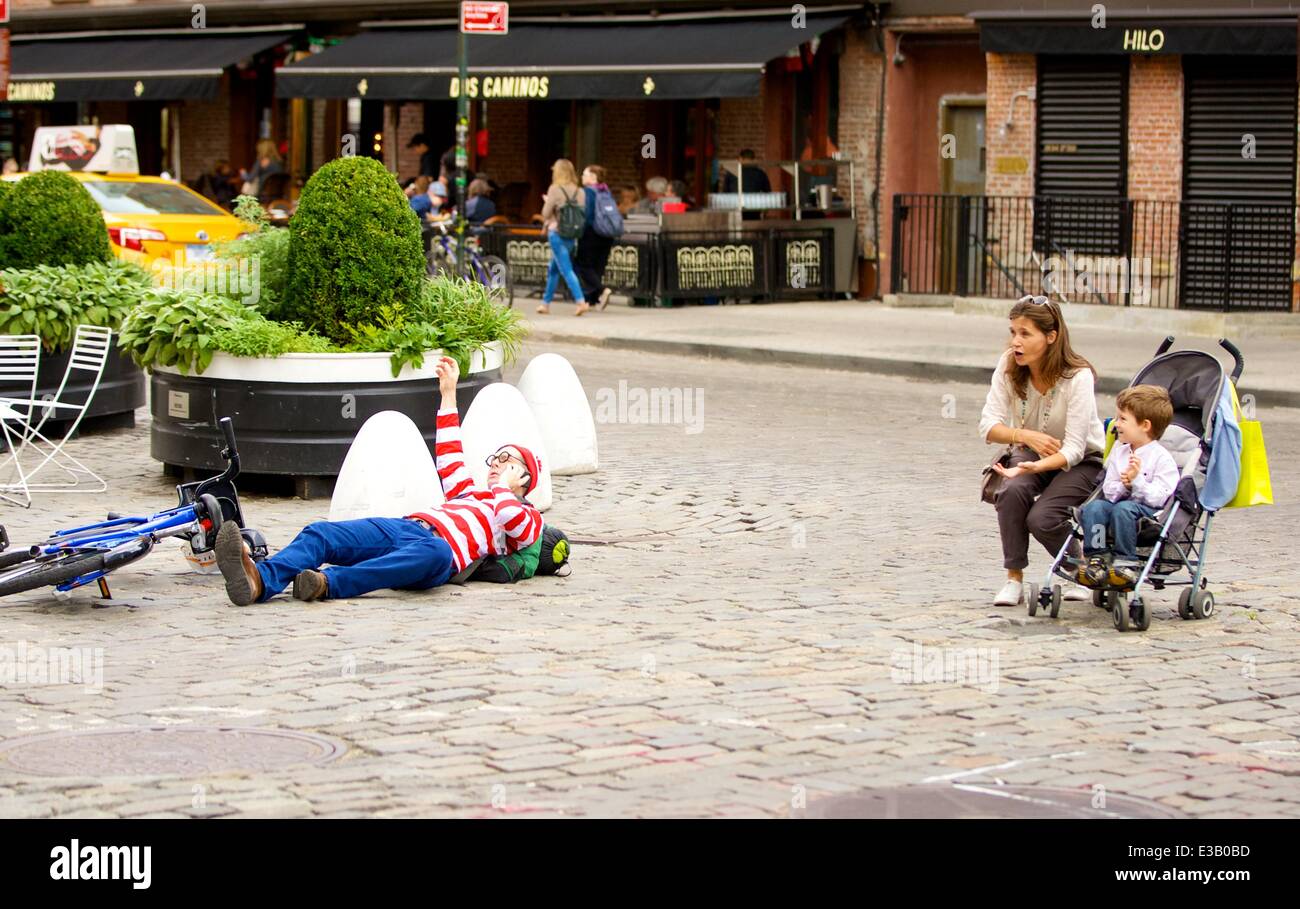 A man dressed as the character Waldo from the children's book series, 'Where's Waldo?' is spotted riding a Citi Bike in the Meatpacking District. With his hands full, Waldo eventually falls off his bicycle to the ground  Featuring: Waldo,Wally Where: New Stock Photo